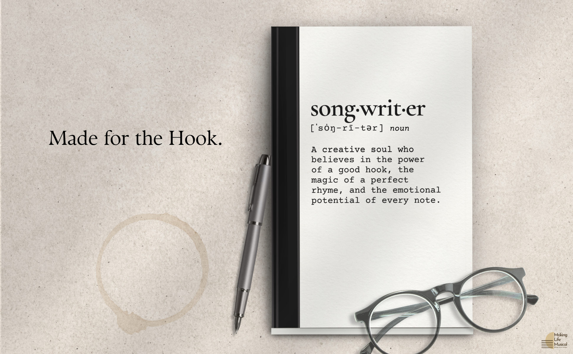 An open notebook with the word 'song writer' defined on the page, alongside a pair of glasses, a pen, and a black book. The background is a beige textured surface with text that reads, 'Made for the Hook.'