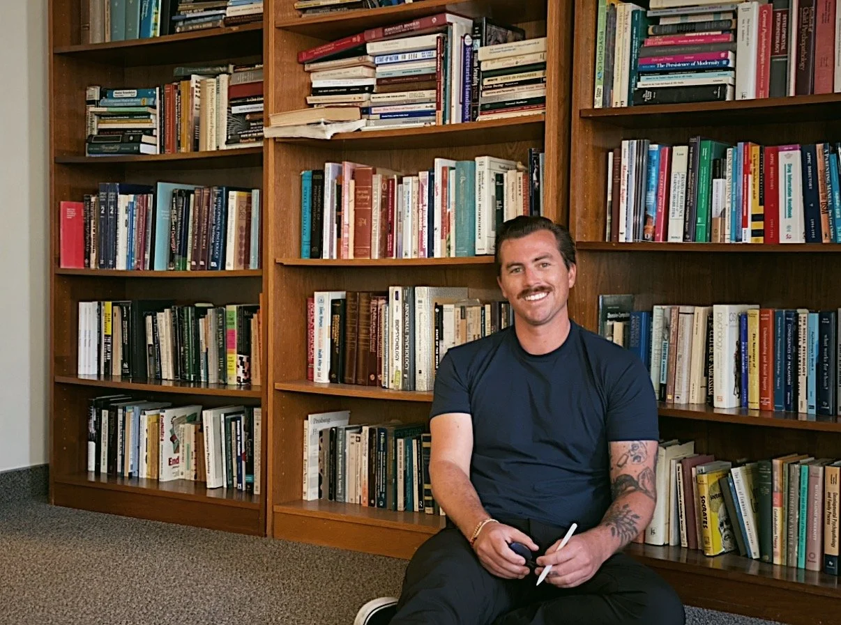 Garrett Rutz seated in front of a bookshelf.