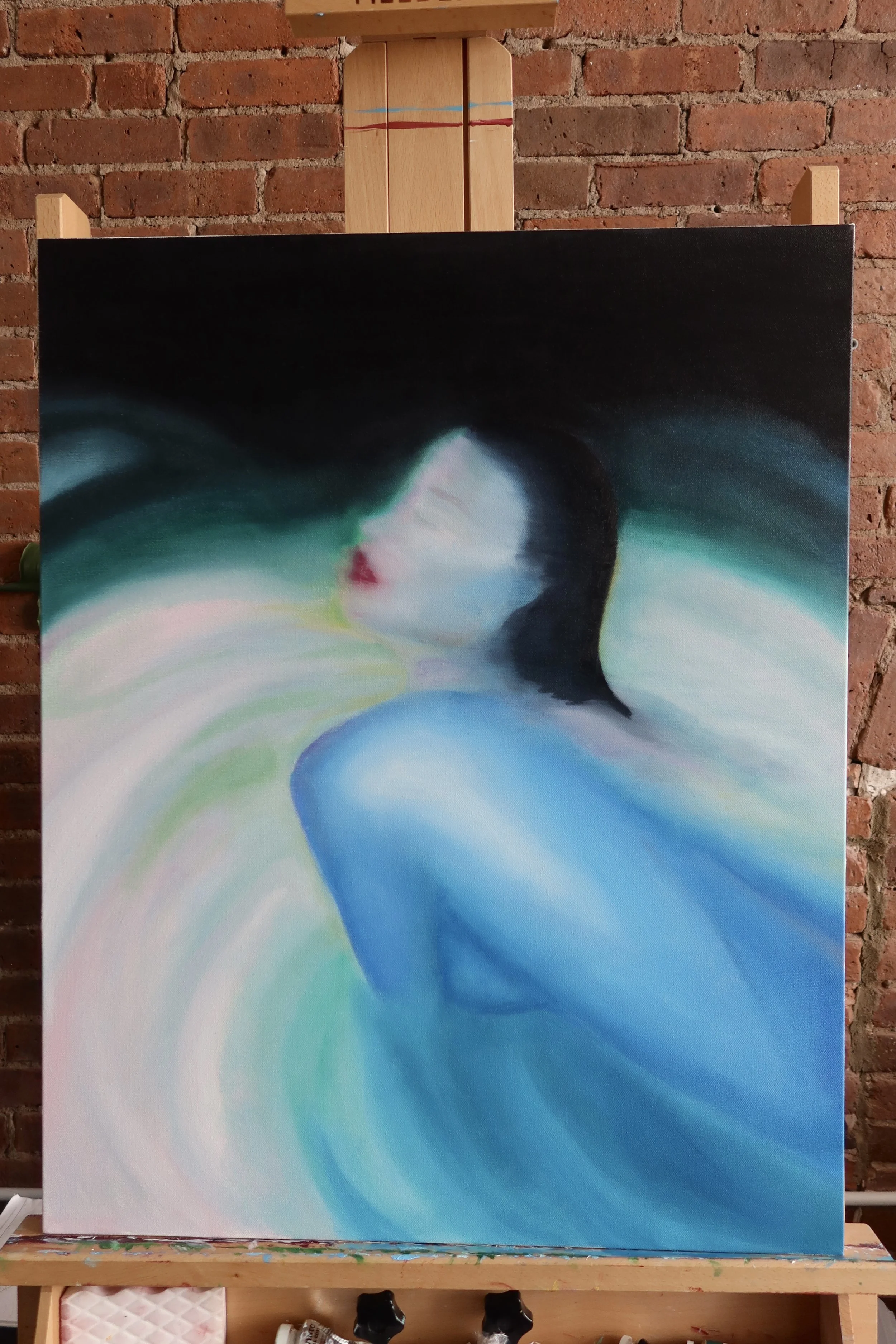 Abstract painting on a canvas depicting a woman's face in profile with flowing hair, featuring soft colors and fluid brushstrokes.