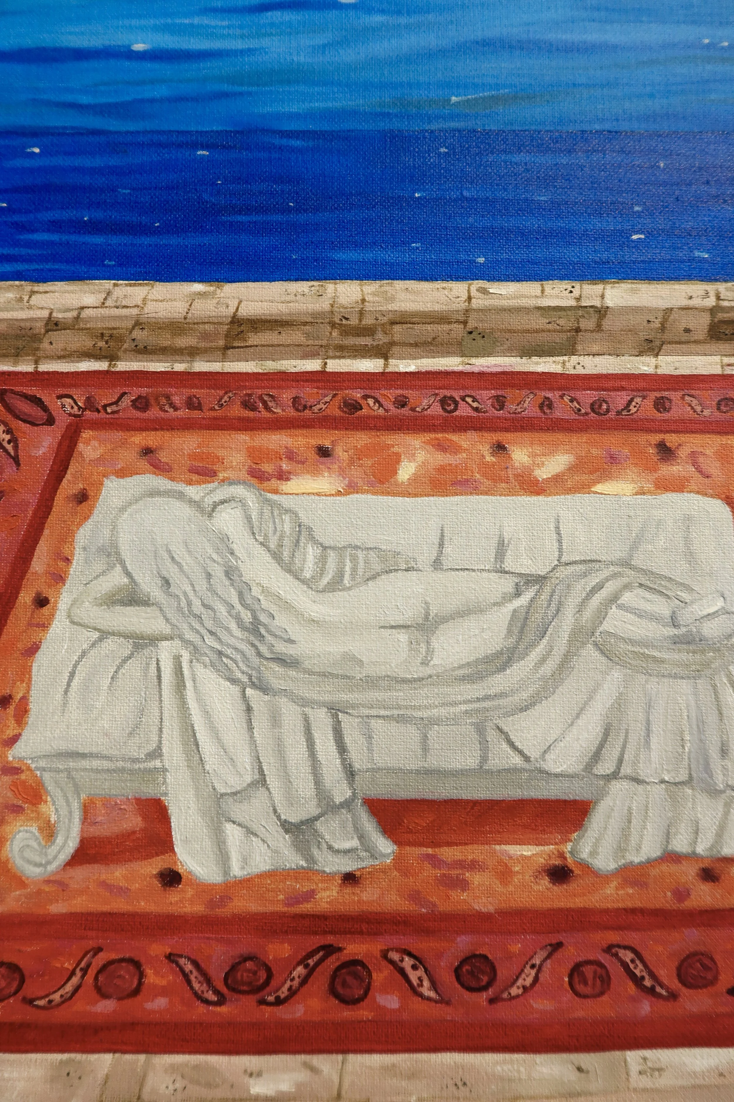 A close-up of a colorful painted wooden bench. The top part is painted blue, followed by a beige section with a brick-like pattern. The bottom part is red with decorative black and red designs, and a white illustration of a horse with a saddle and br