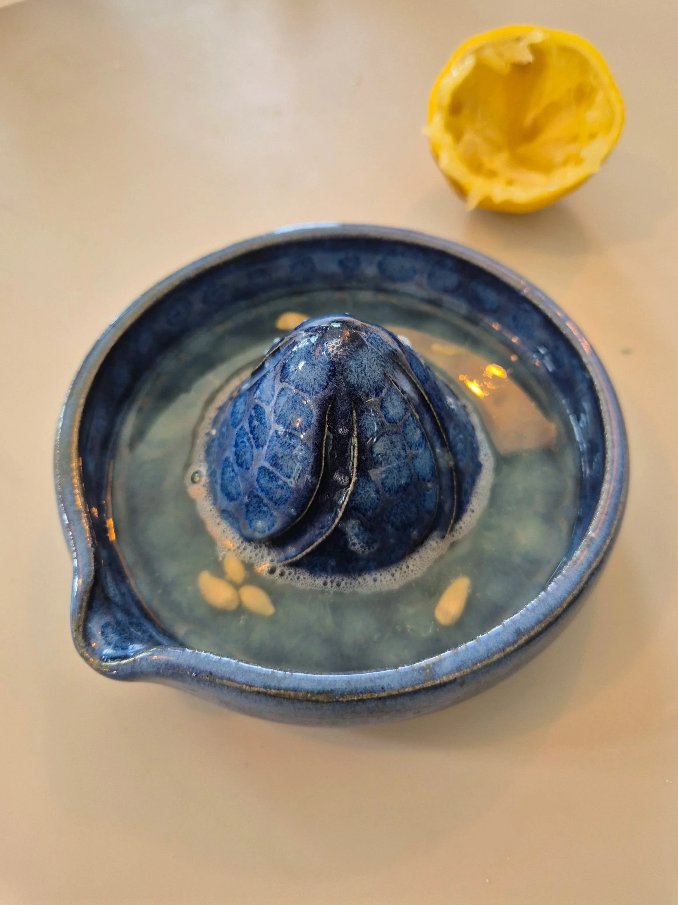 A handmade lemon juicer being tested. using homemade pottery glazes