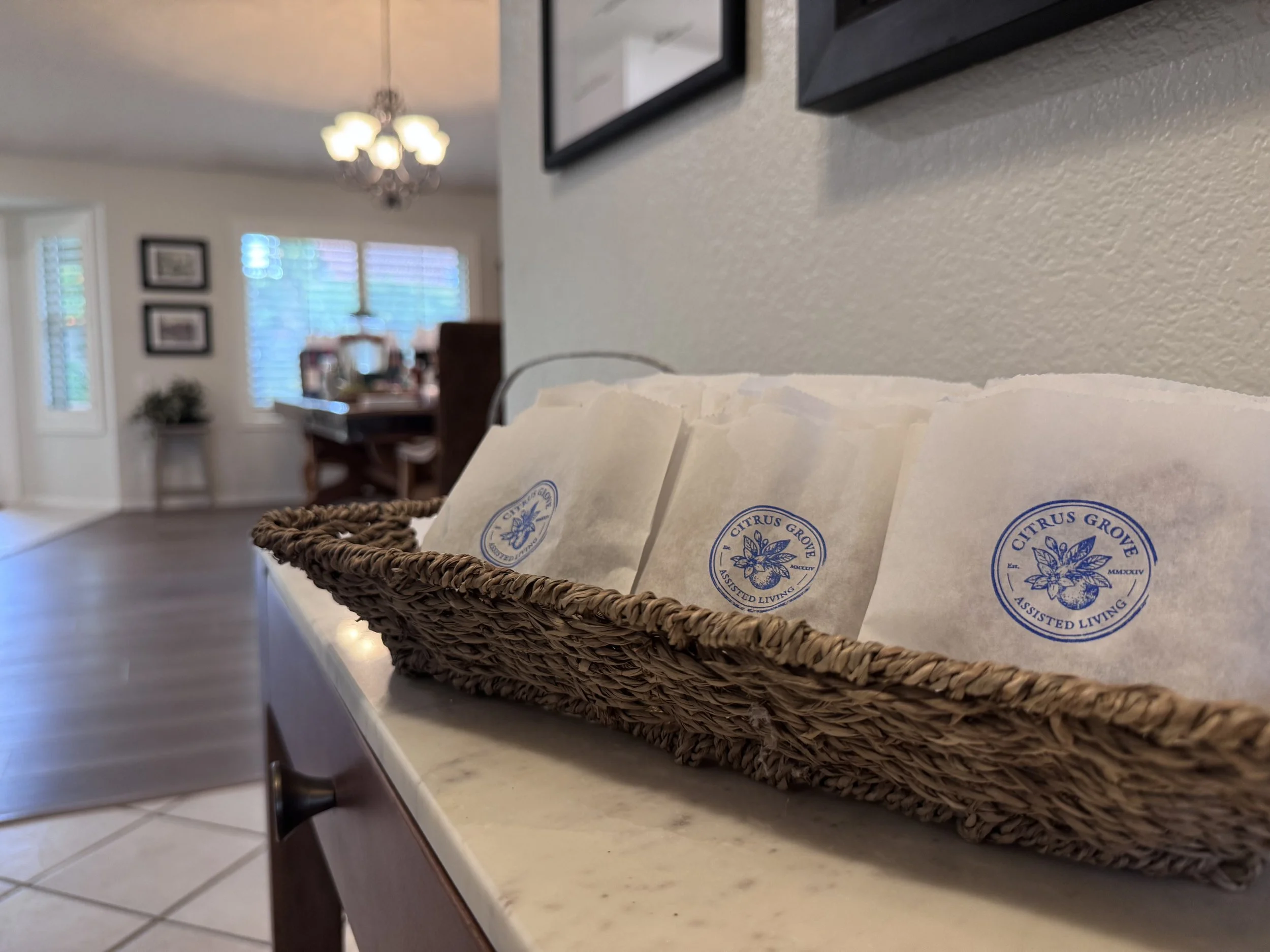 A woven basket holding packets of citrus grove themed items on a white countertop in a home interior.