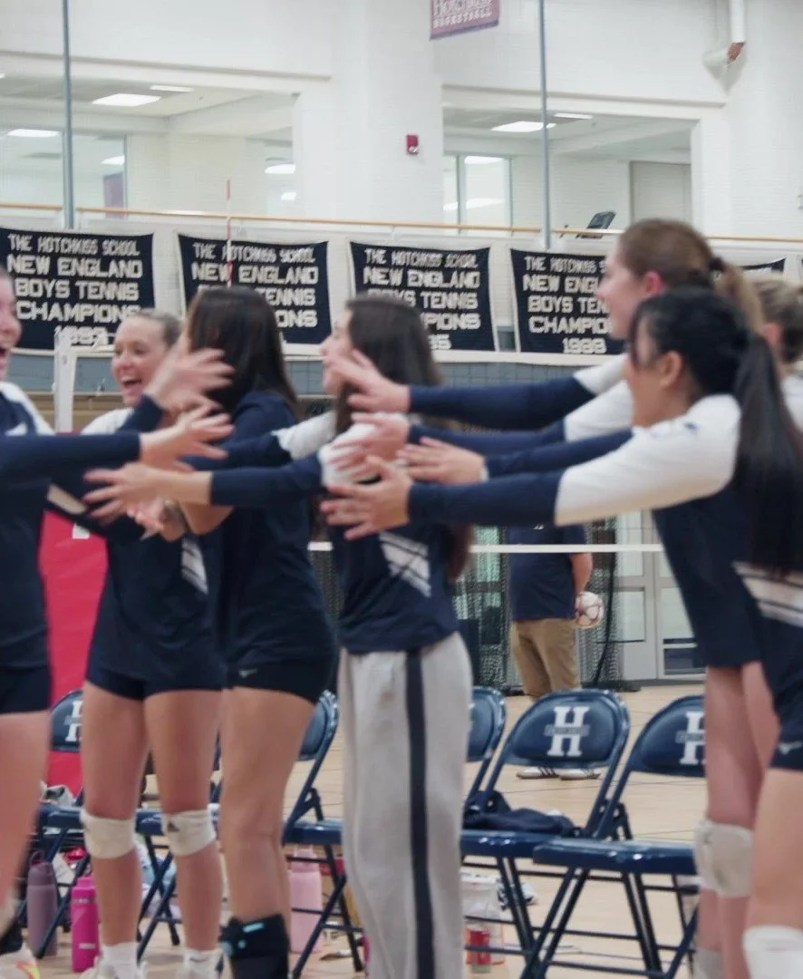 Hotchkiss girls volleyball players celebrating together on the court