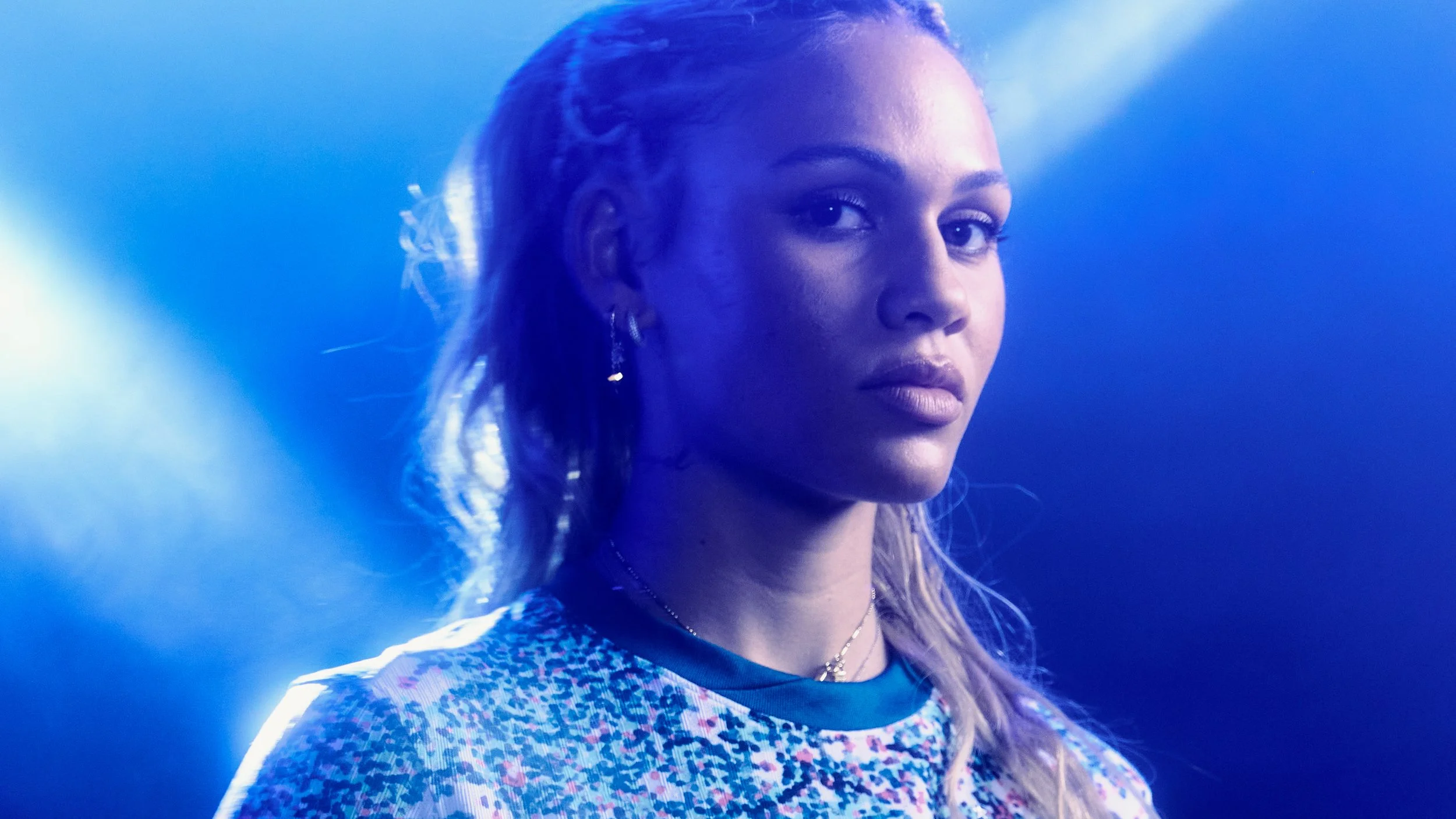 Close-up of Trinity Rodman lit with dramatic blue lighting.