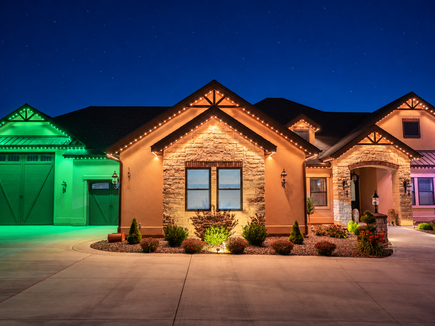 Green lighting above a garage contrasts with amber lighting around an adjacent stone gable and entryway.