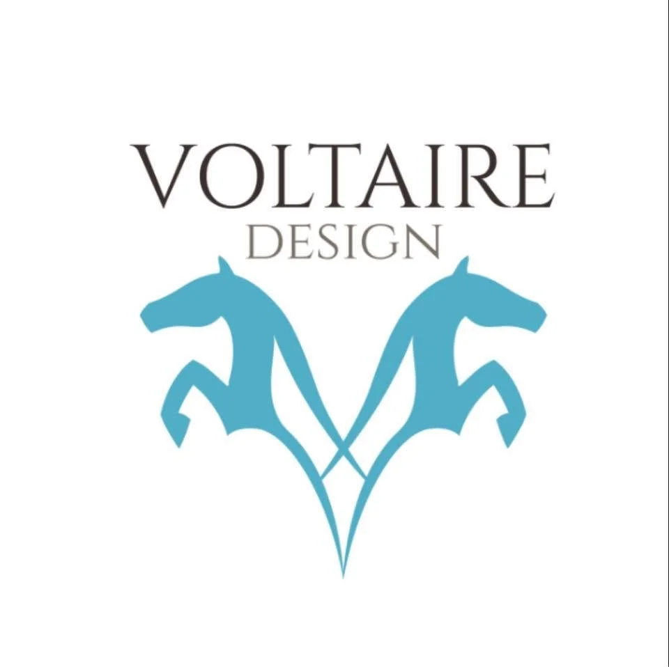 Logo for Voltaire Design featuring two blue horse heads facing opposite directions.