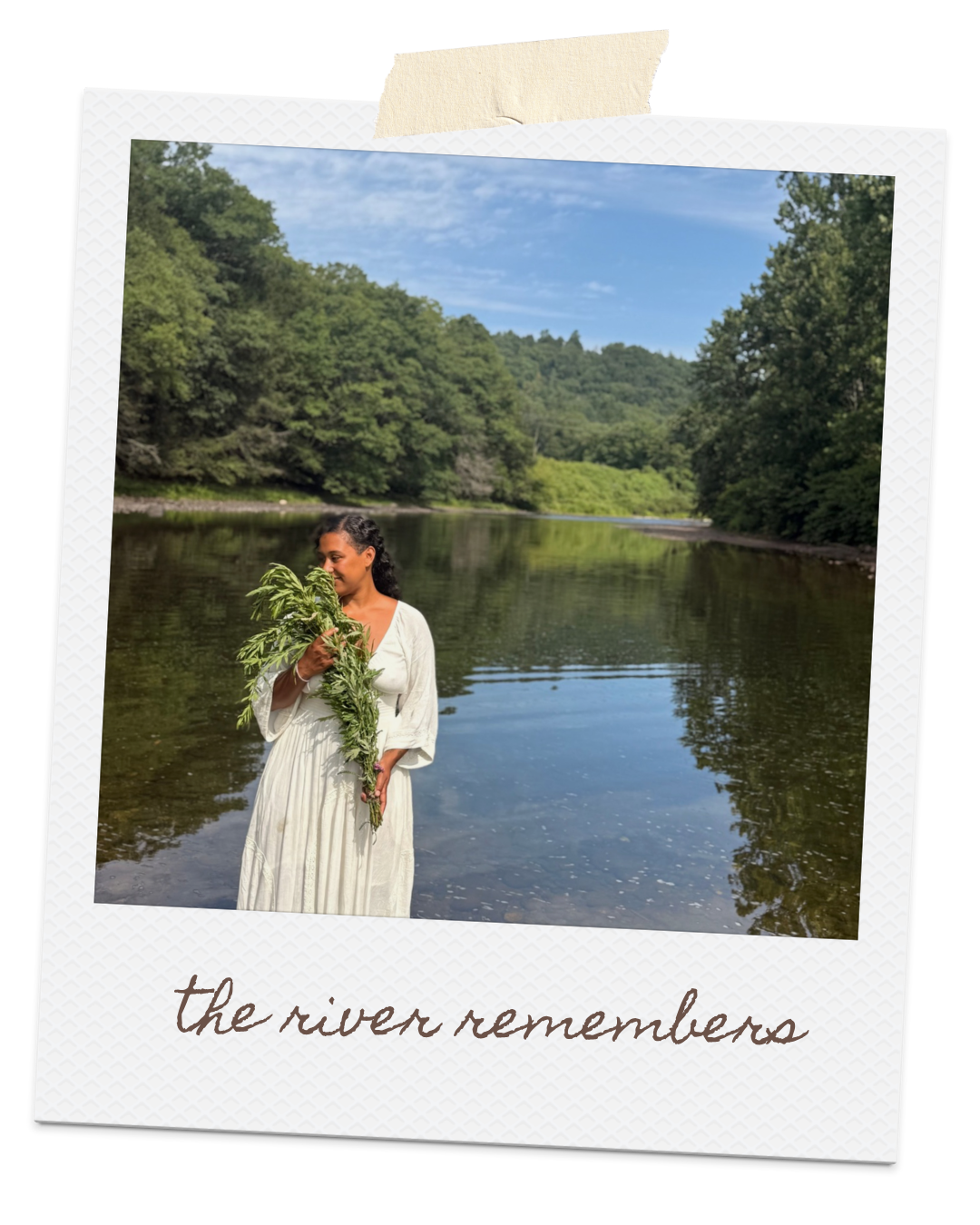 Amber Arnold in a white dress by a river holding a large bouquet of greenery, with a forested landscape and blue sky in the background, and the text 'the river remembers' written at the bottom.