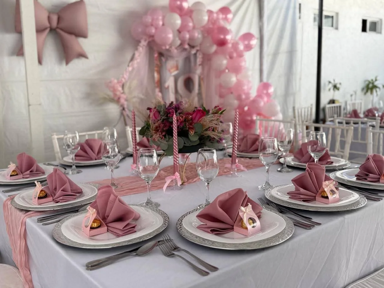 Mesa decorada para fiesta femenina XV años
Banquetes Del Roble con vajilla fina y decoración rosa