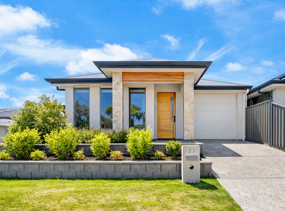 Modern single-story home with landscaped front garden, wood entry door, attached garage.