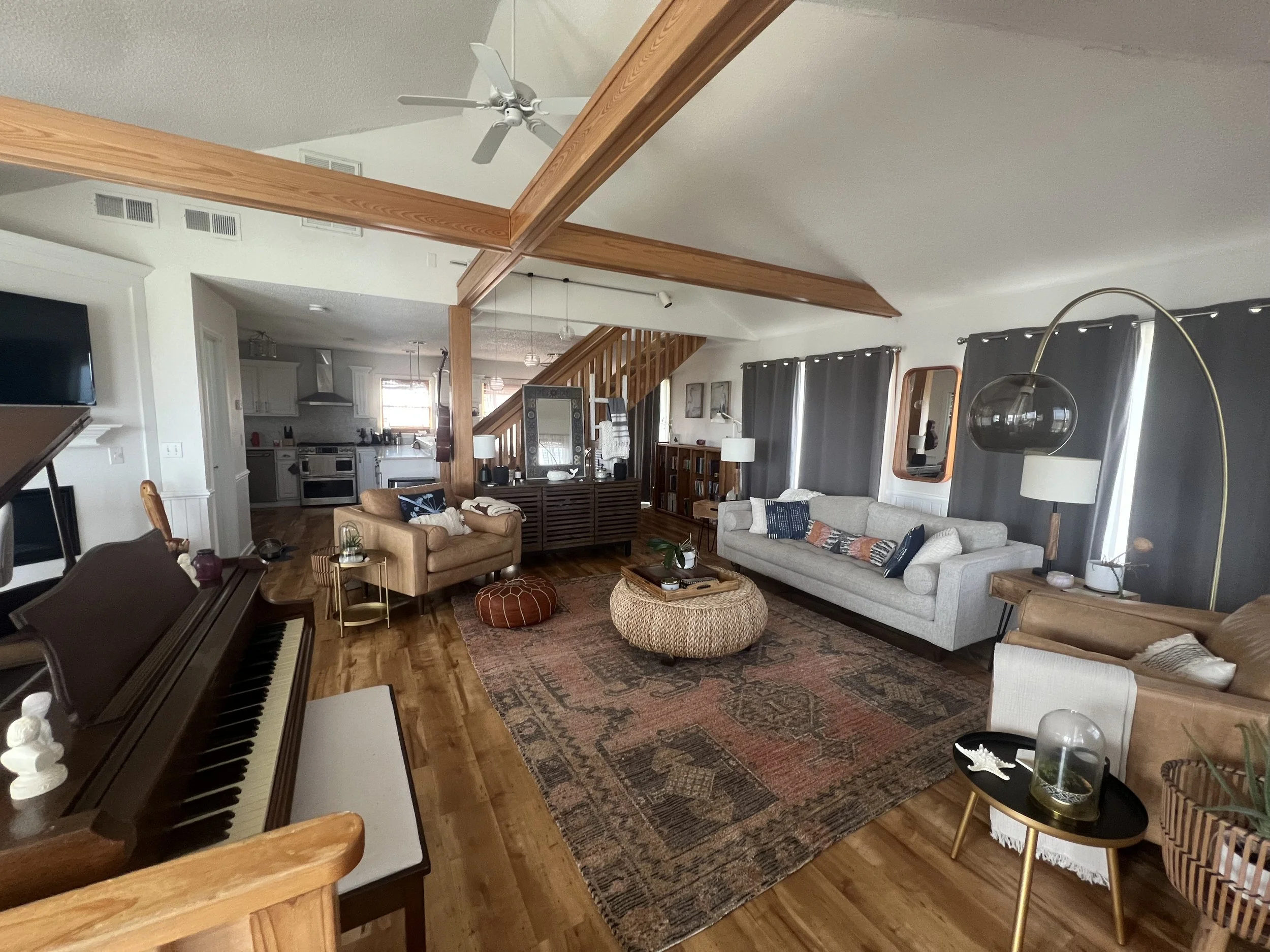 Living room with a couch, armchair, coffee table, area rug, piano, and various decorations.