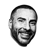 Black and white photo of Chris with short hair and a beard, smiling.
