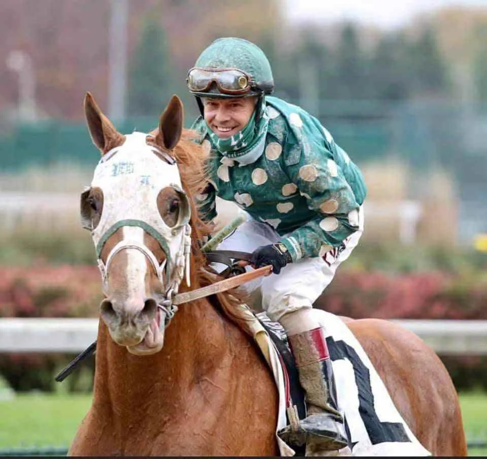Horse racing jockey riding a horse on a race track