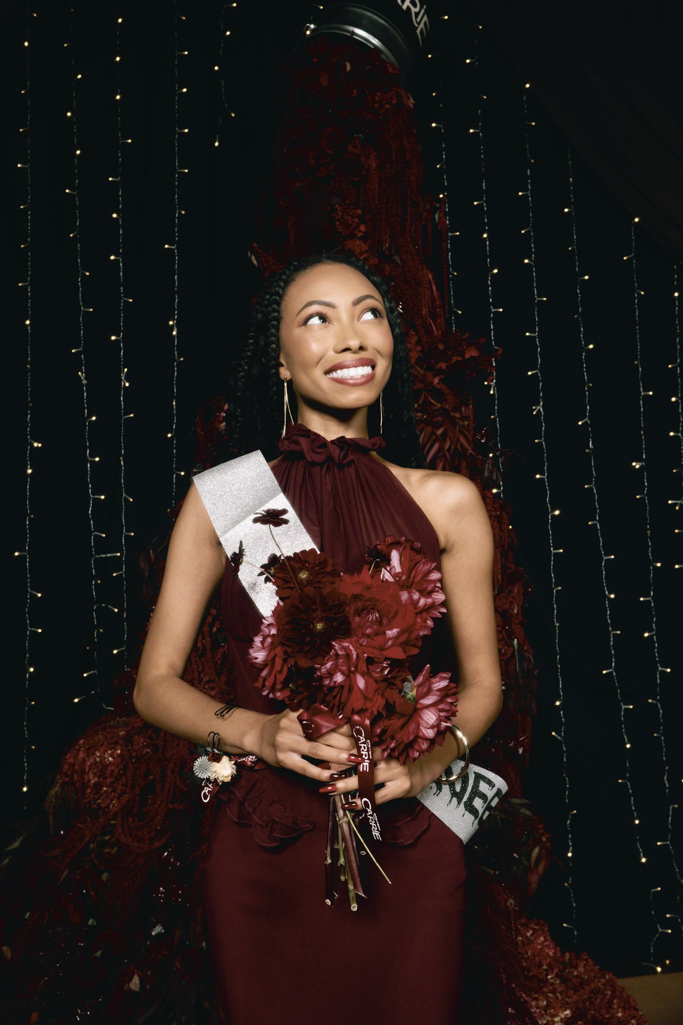 Bree Stephensin a burgundy floral gown holding a bouquet at an event for Carrie.