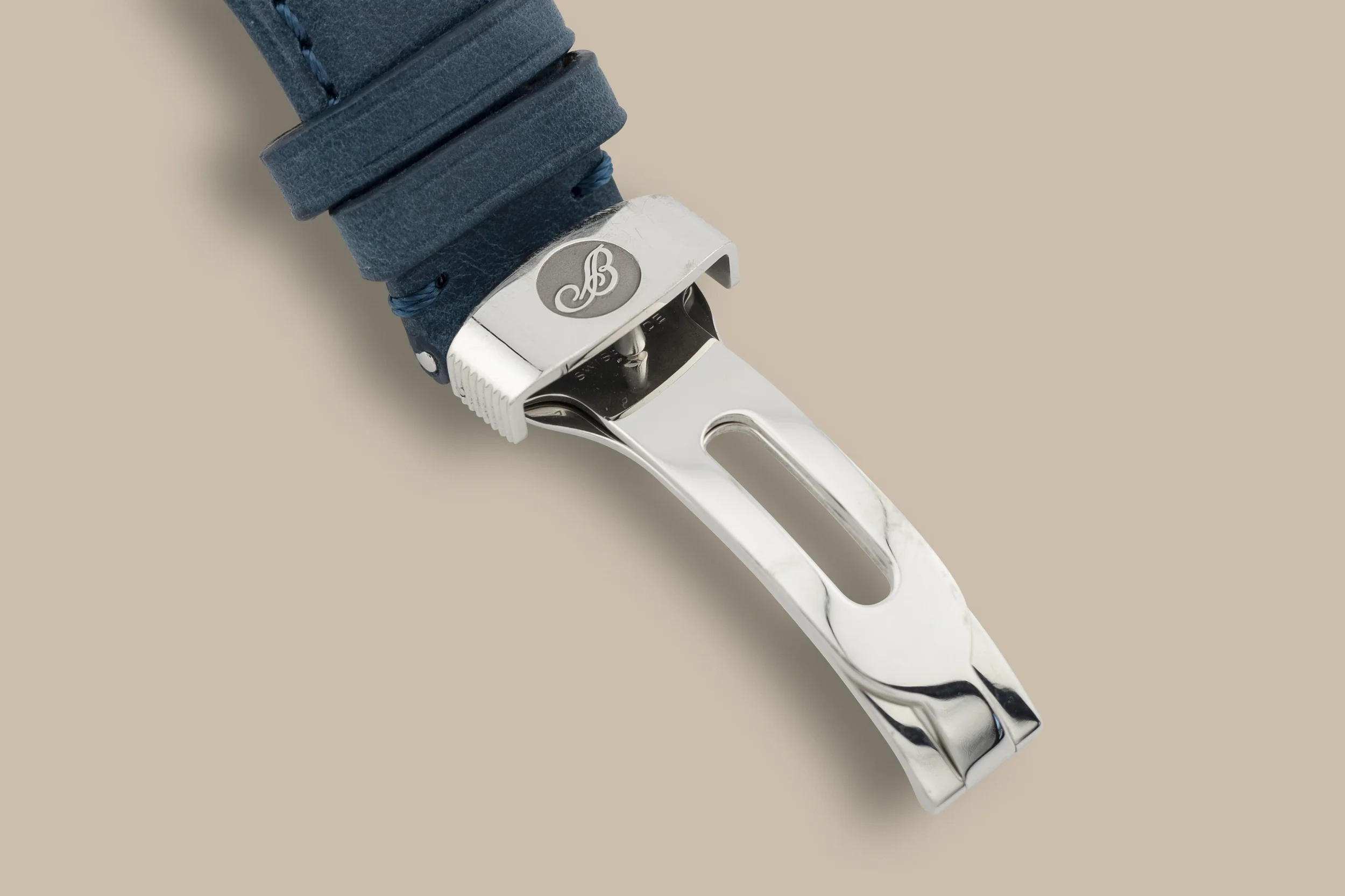 Close-up of a silver hair clipper with a black and white patterned power cord on a beige background.