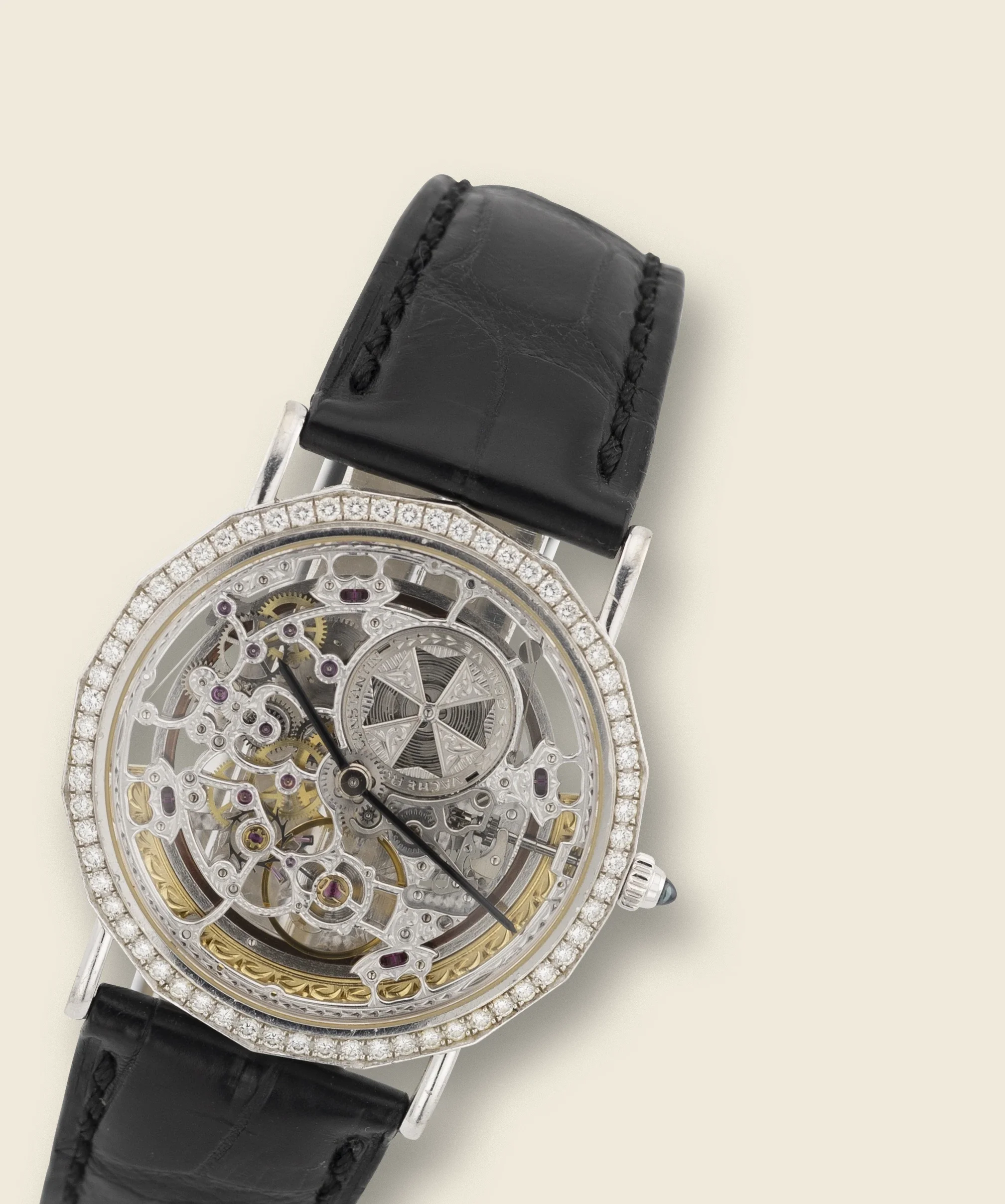 Close-up of a women's wristwatch with a skeleton dial, diamond-studded bezel, and black leather strap.