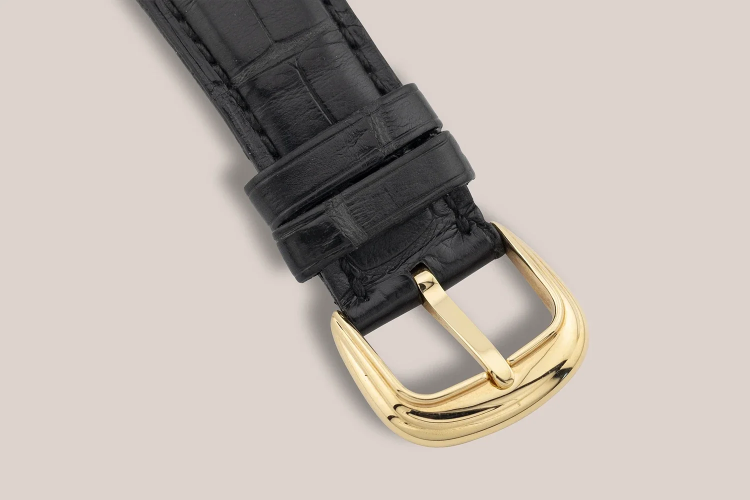 black leather watch strap with a gold buckle
