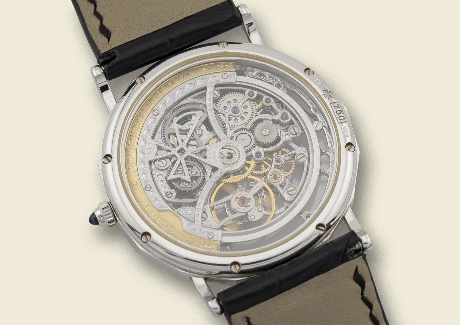 Close-up of a luxury skeleton watch with visible internal gears and mechanisms, black leather strap, and stainless steel casing.