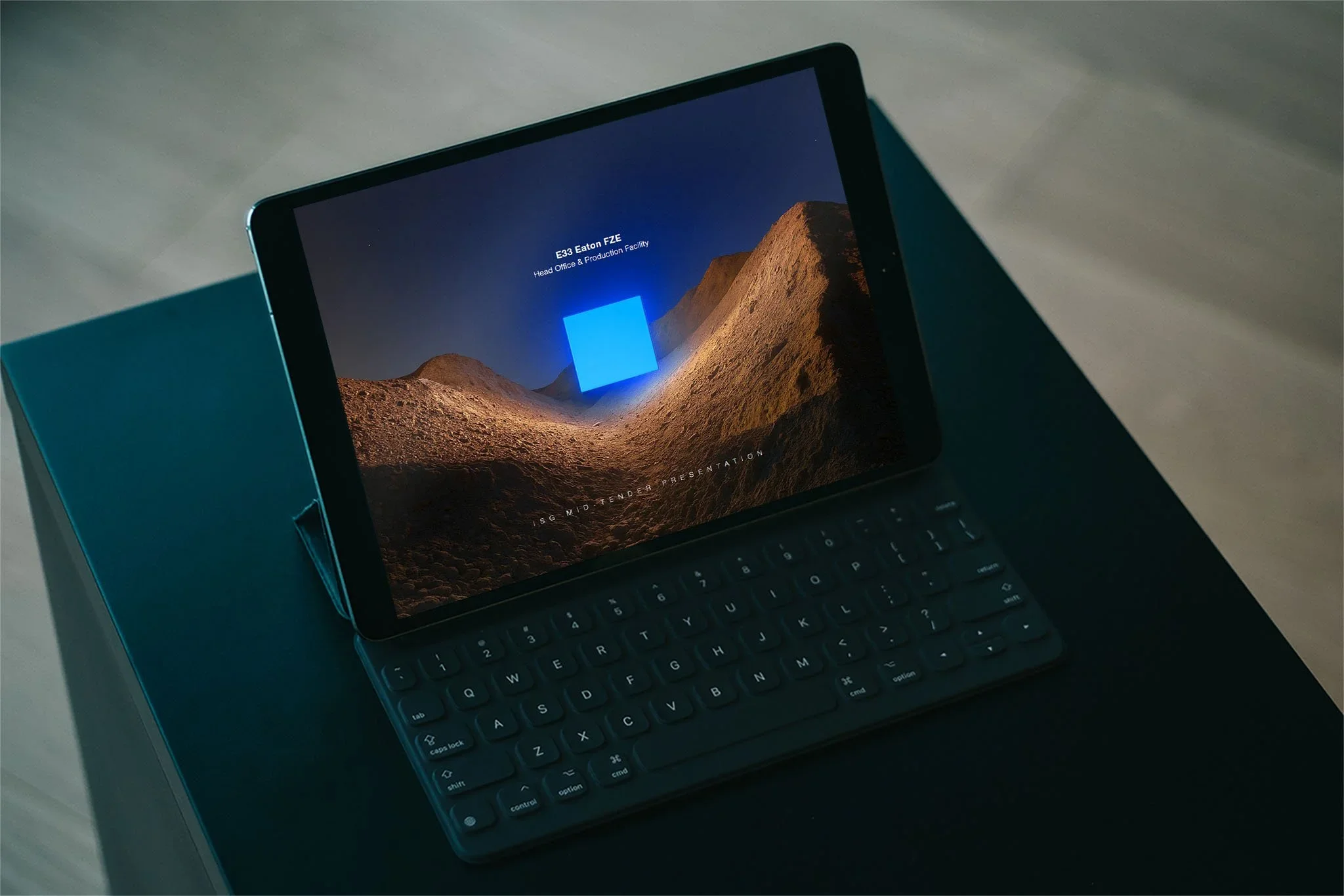 A tablet with a keyboard displaying a landscape scene of sand dunes and a night sky with stars, titled 'E33 Eaton FZE Head Office & Production Facility'.