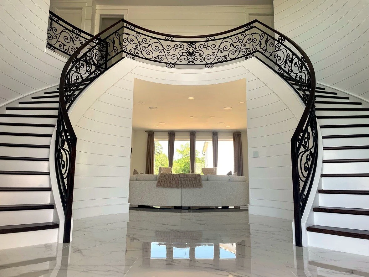 Curved stair with forged scroll railing