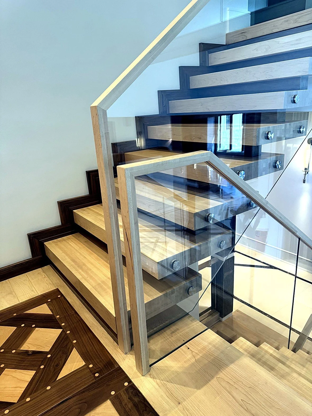 The Blockley stacked-block staircase, finished switchback with glass railing on standoff pins