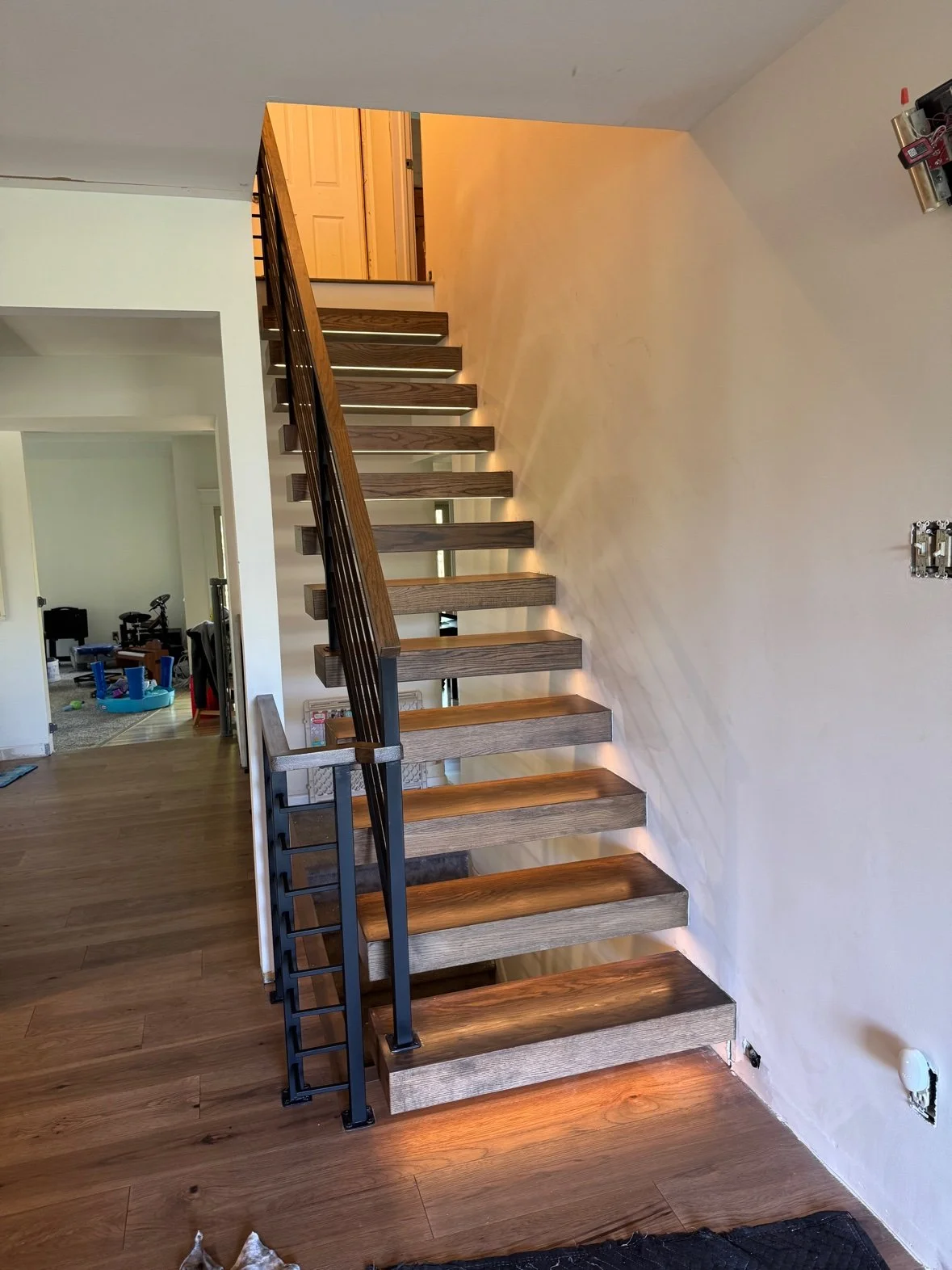 Flight along the wall, with wood treads and under-tread lighting