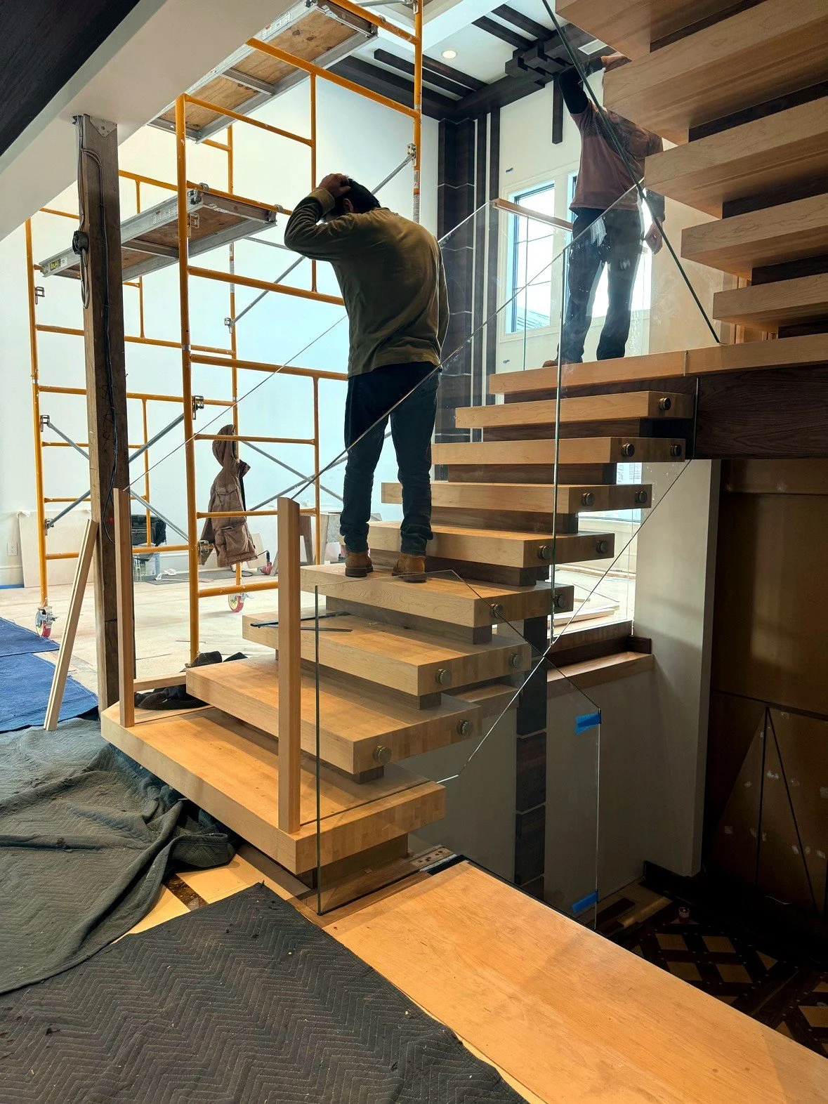 The Blockley stacked-block staircase during installation, fitting glass railing