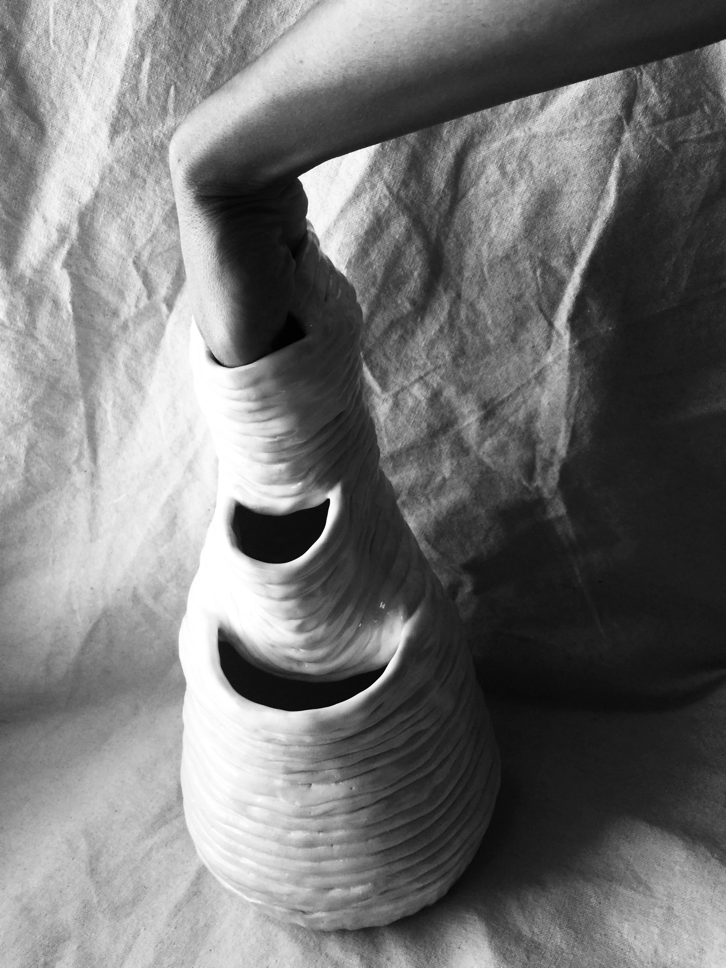 A black-and-white photo of rolled-up paper towels stacked on a textured surface.