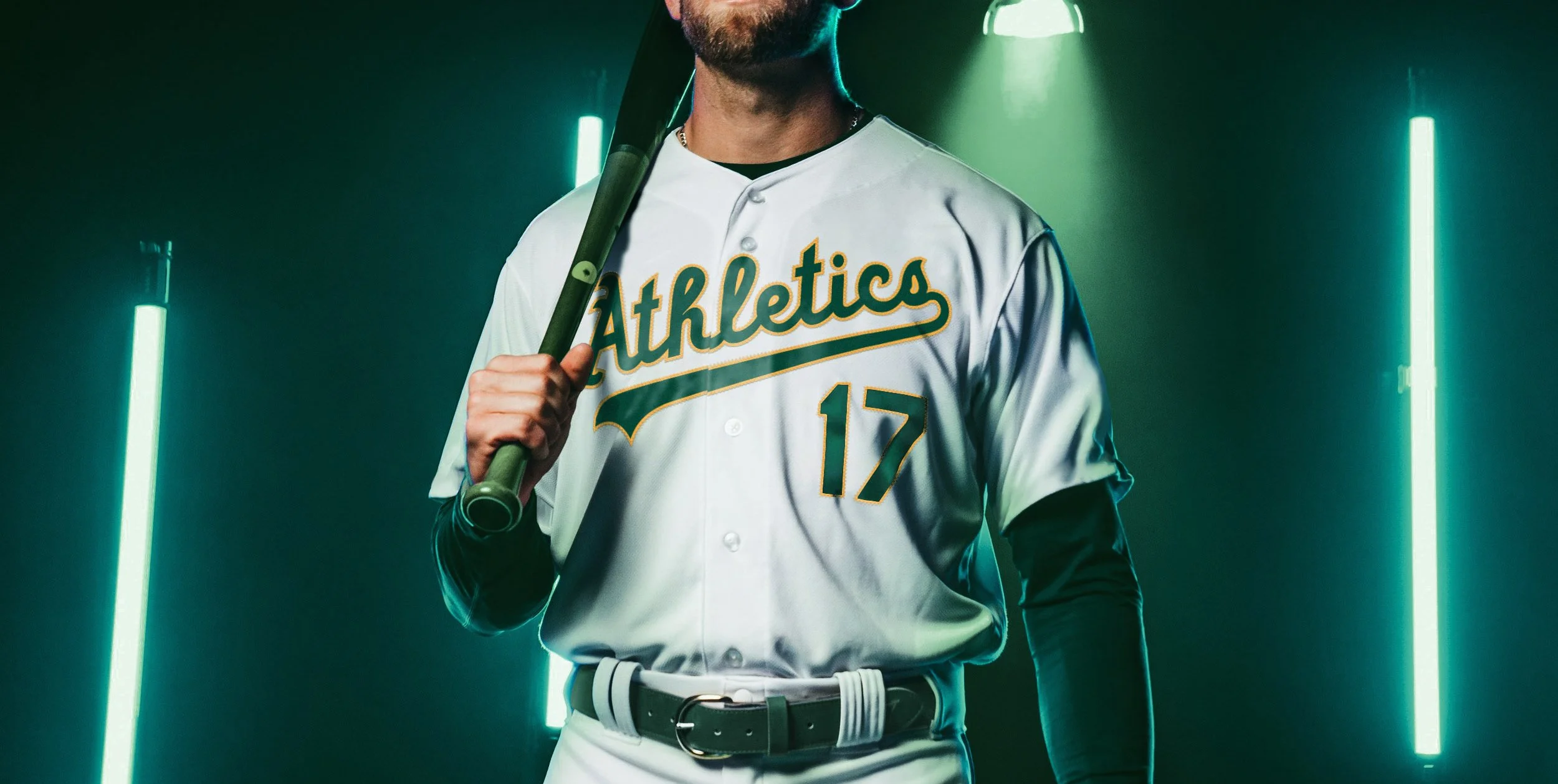 A person is wearing a white baseball jersey with green and yellow accents, holding a baseball bat over their shoulder, standing in front of neon green lights.