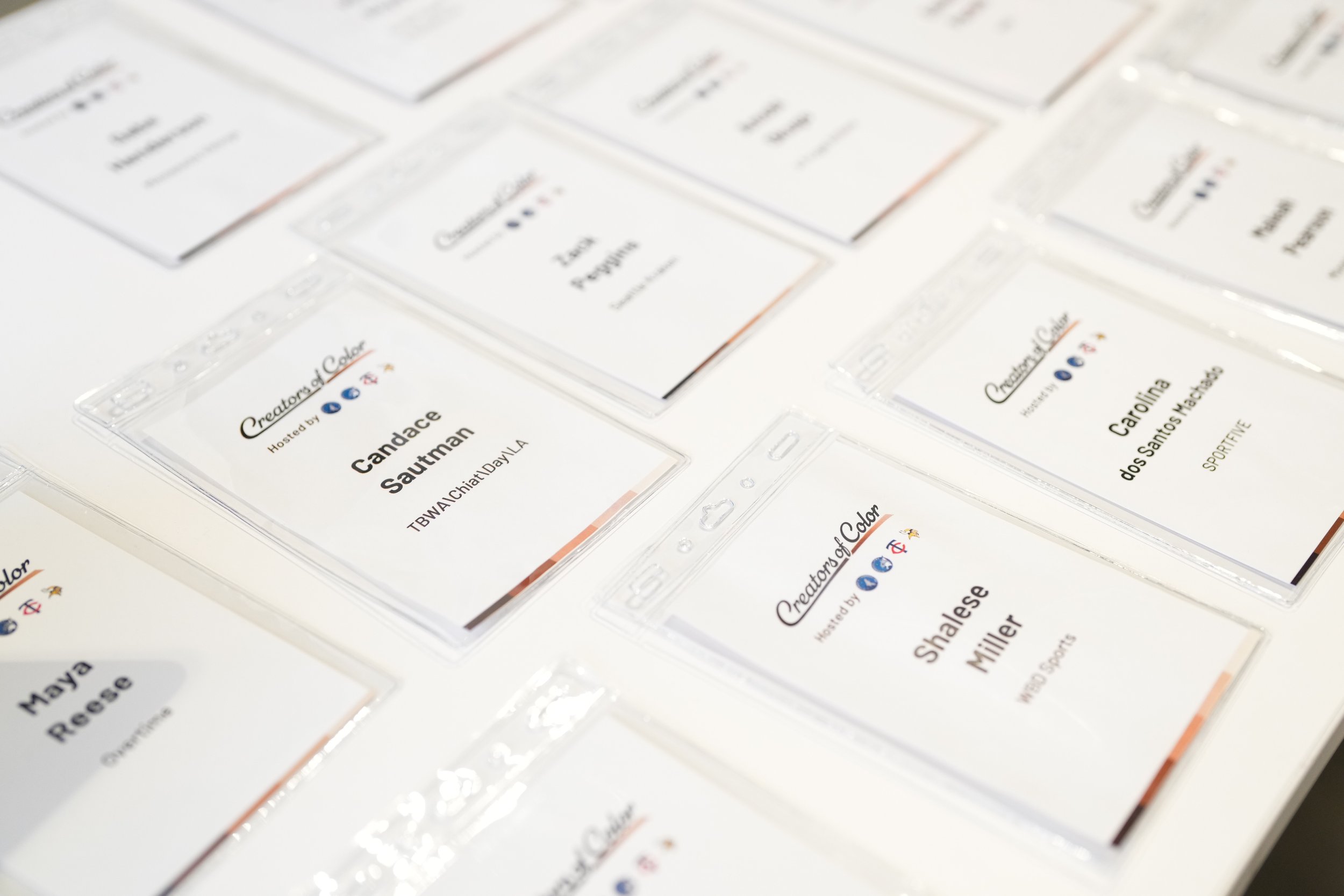 Event name badges with attendee names and affiliations arranged on a table.