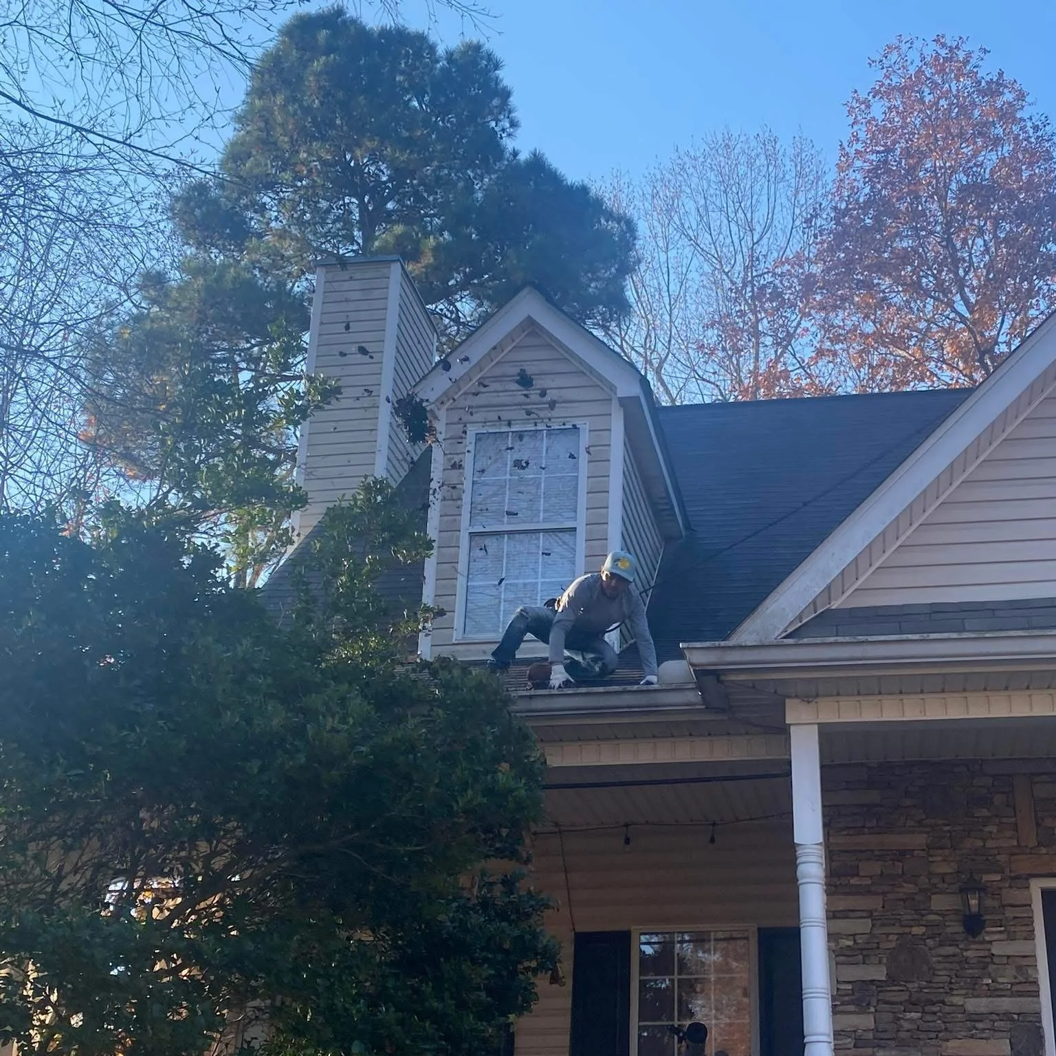 Person repairing a house roof near a dormer window
