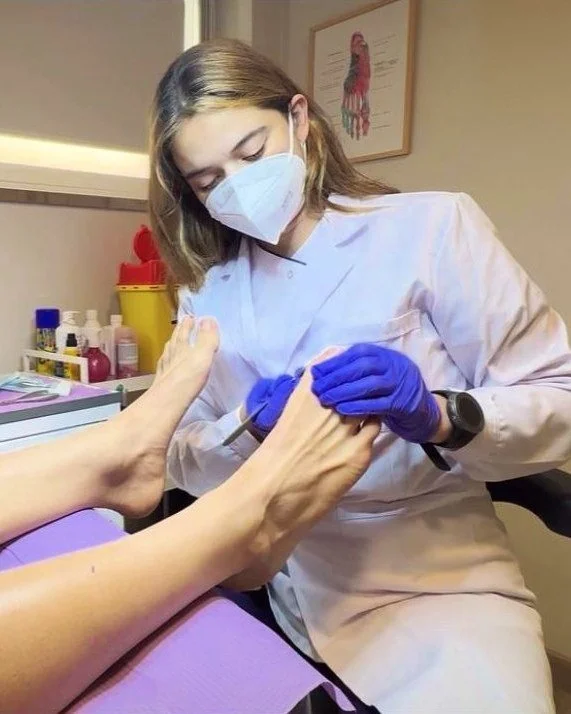 Alejandra Castaño, podóloga, haciendo una quiropodia a una paciente en su consulta de Les Corts