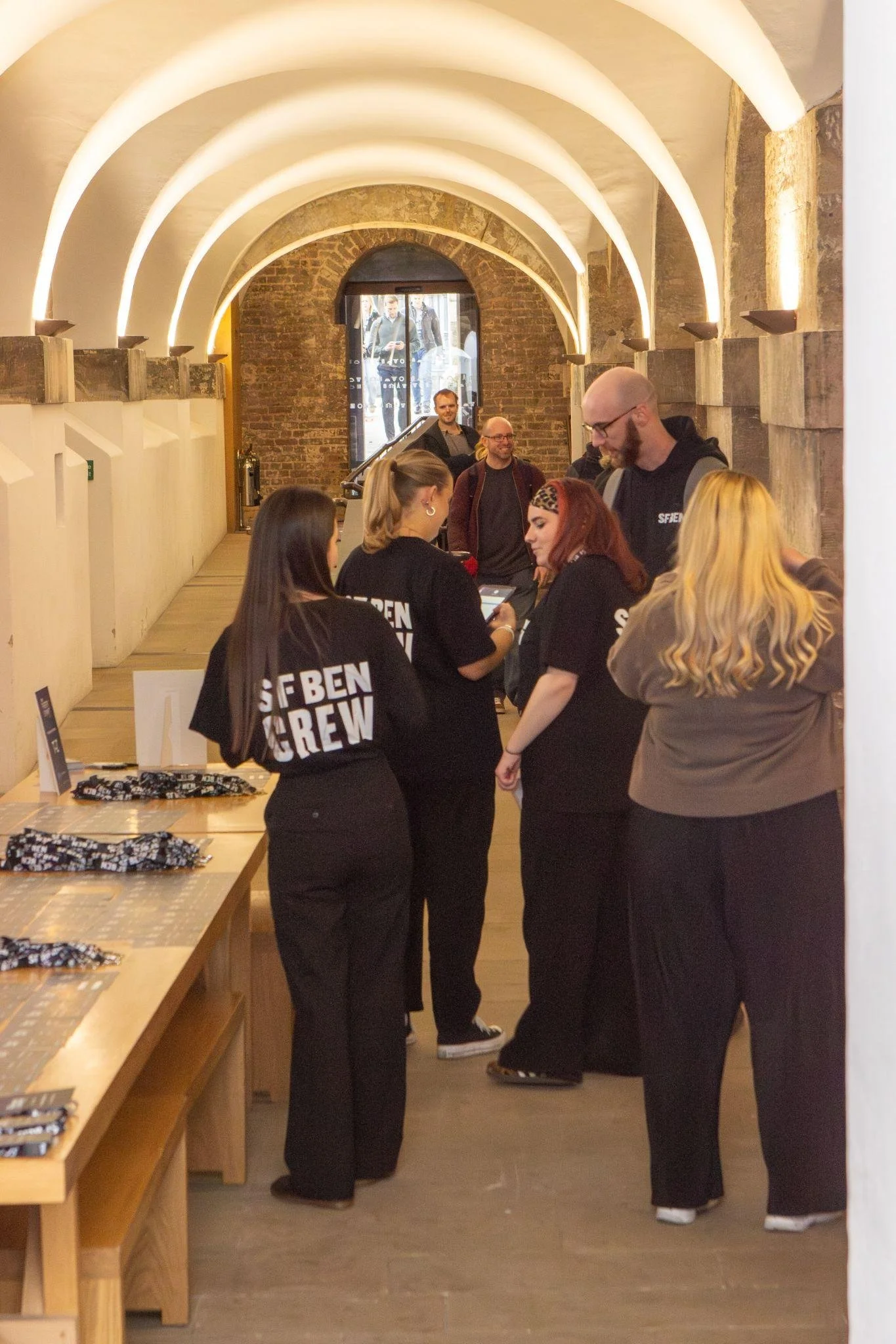 Event crew welcoming attendees beside the registration table in the Crypt at Christ Church Spitalfields.