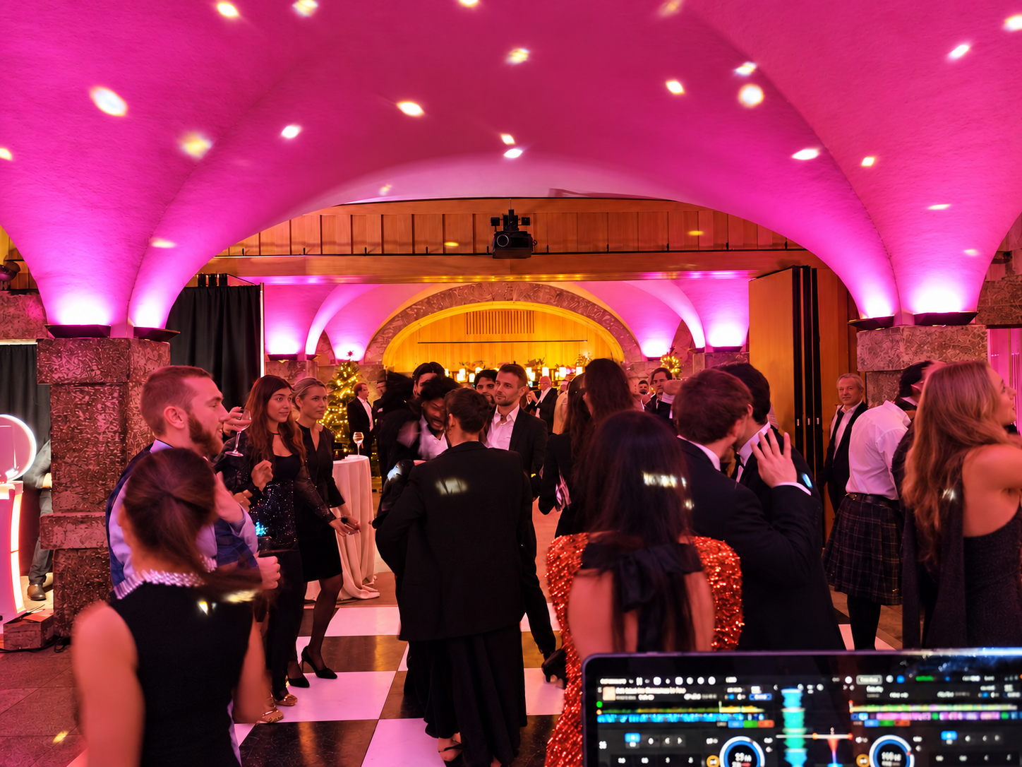 Guests dancing under pink and amber lighting at a Christmas party in the Crypt.