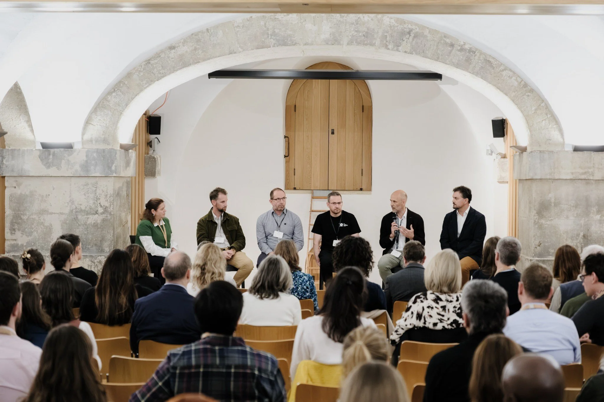 Panel discussion beneath the Crypt’s stone arches at Christ Church Spitalfields, with a seated audience