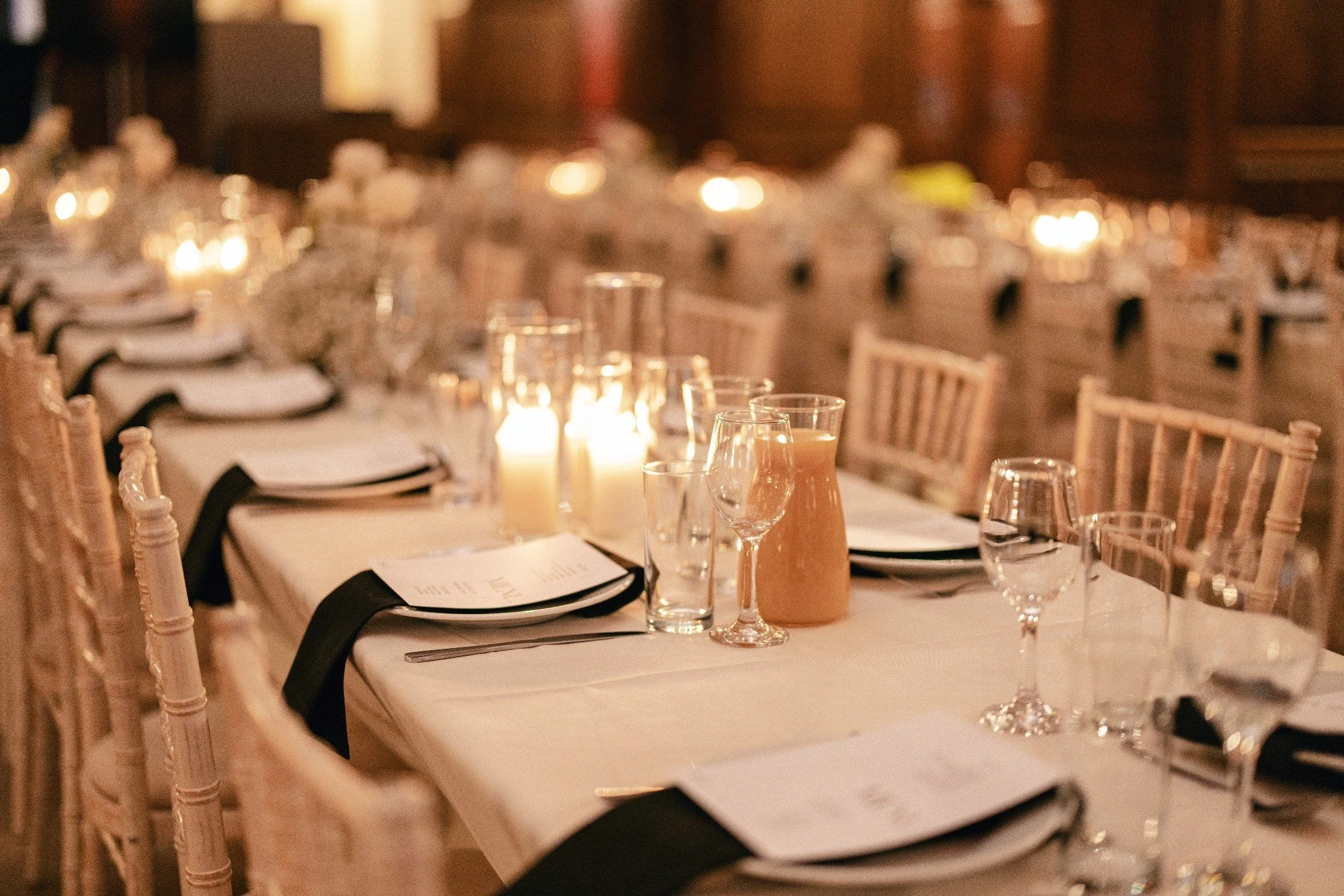 Candlelight, glassware and place settings on a wedding table.