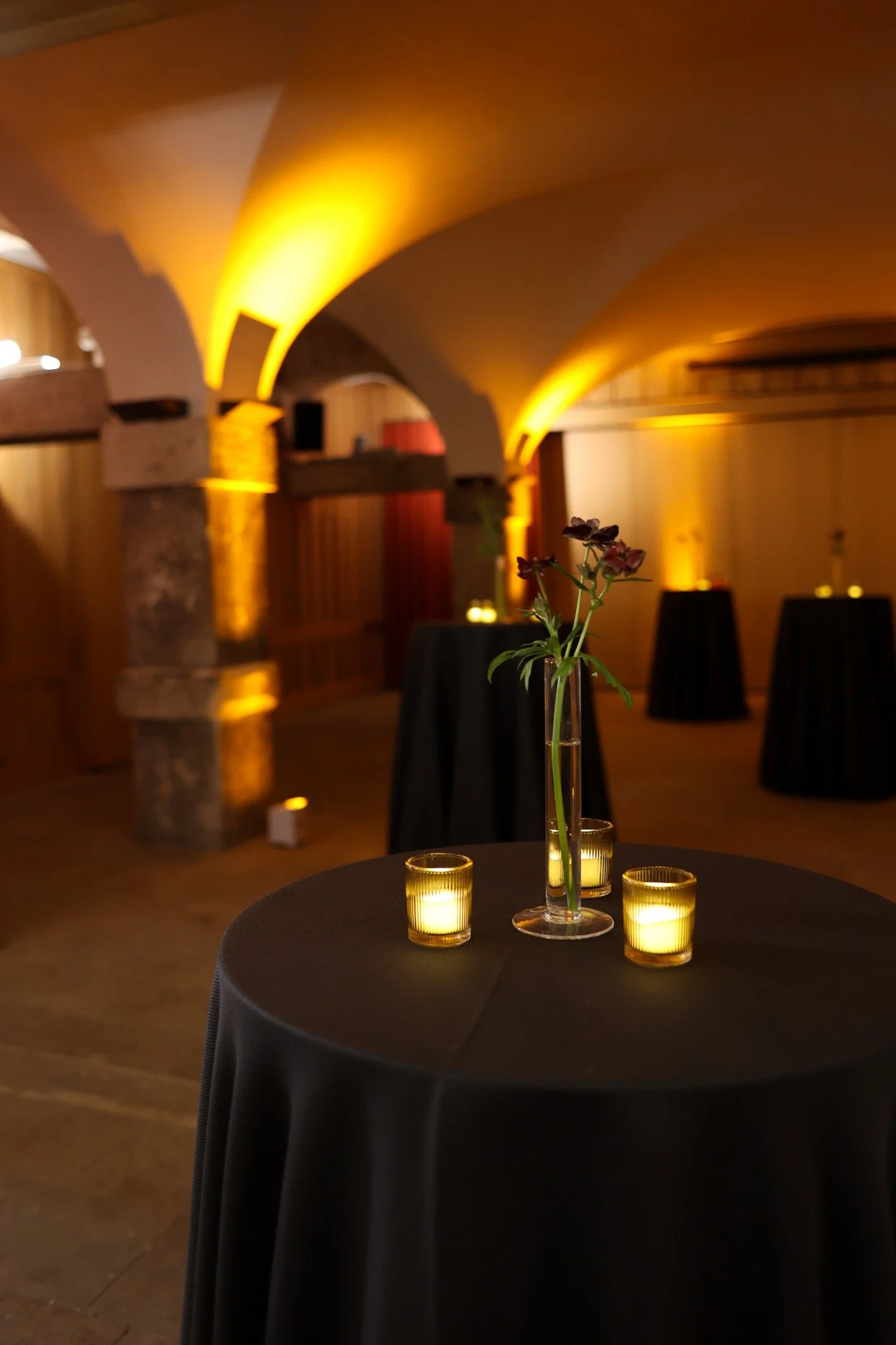 Candlelit poseur tables beneath the warmly lit Crypt arches.