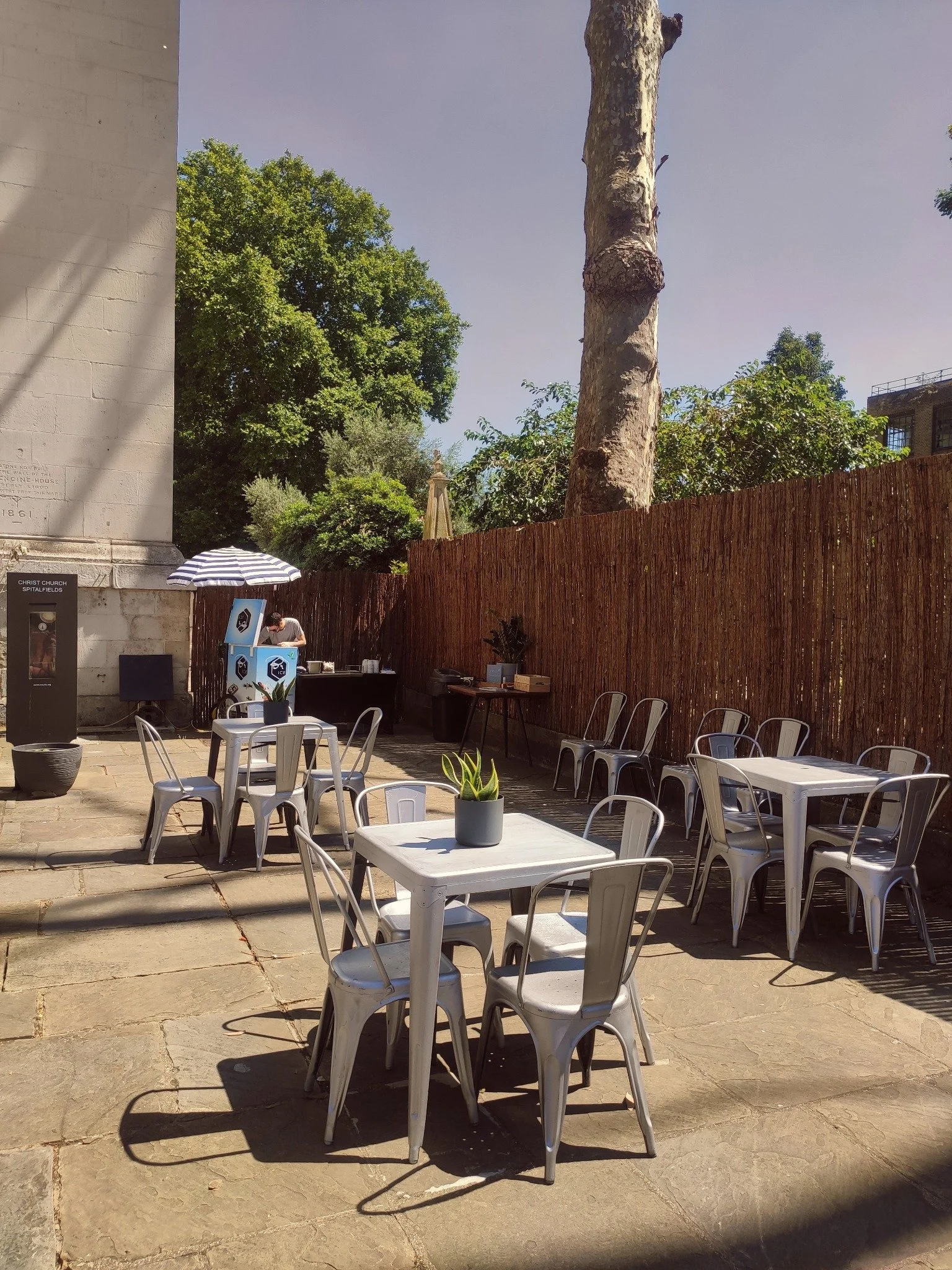 Sunlit Courtyard with outdoor tables, chairs and an ice cream stand.