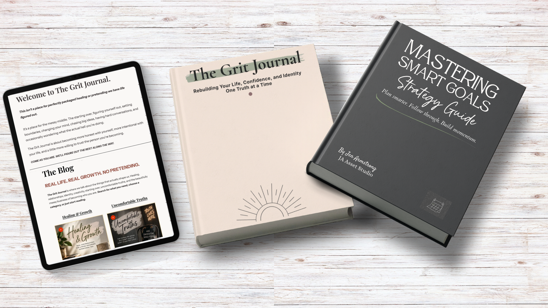 Two self-published books by Jenn Armstrong, The Grit Journal and Mastering SMART Goals, displayed alongside The Grit Journal blog on a tablet.