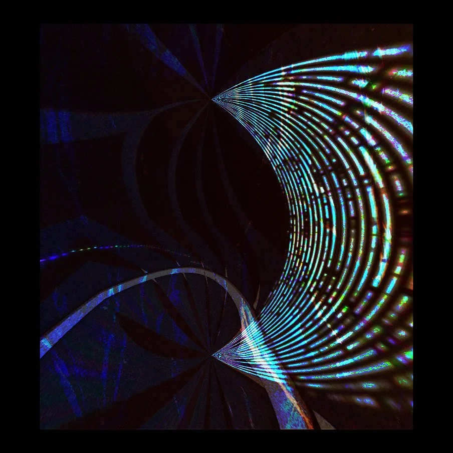 Colorful light display with arcs and lines projected on a dark surface.