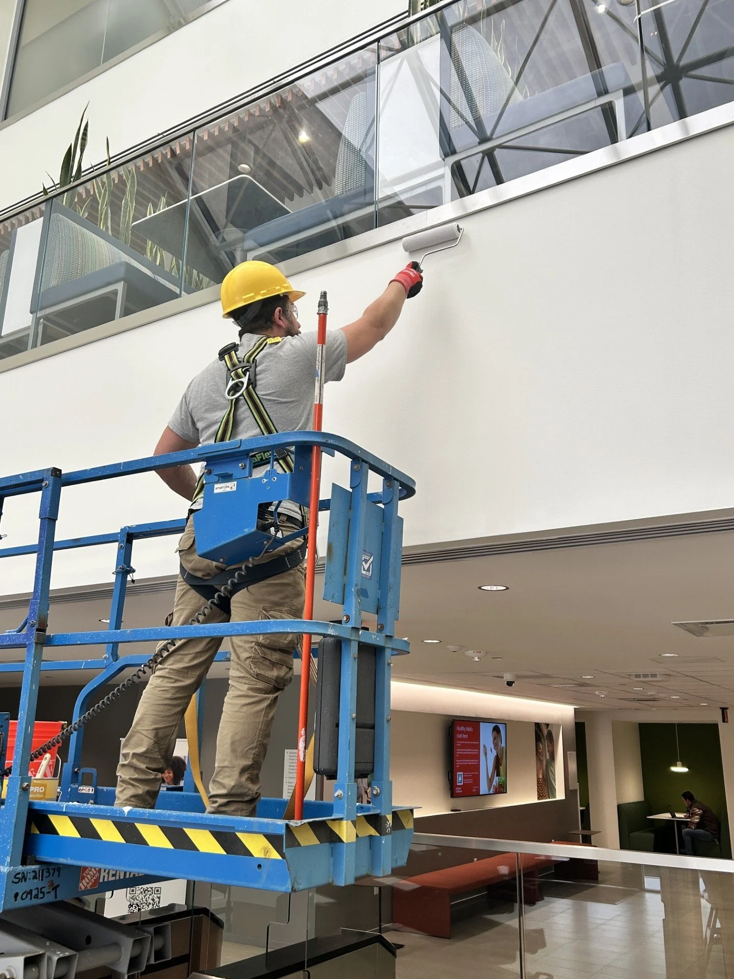 SJS Construction crew working from a scissor lift on a large-scale commercial facility