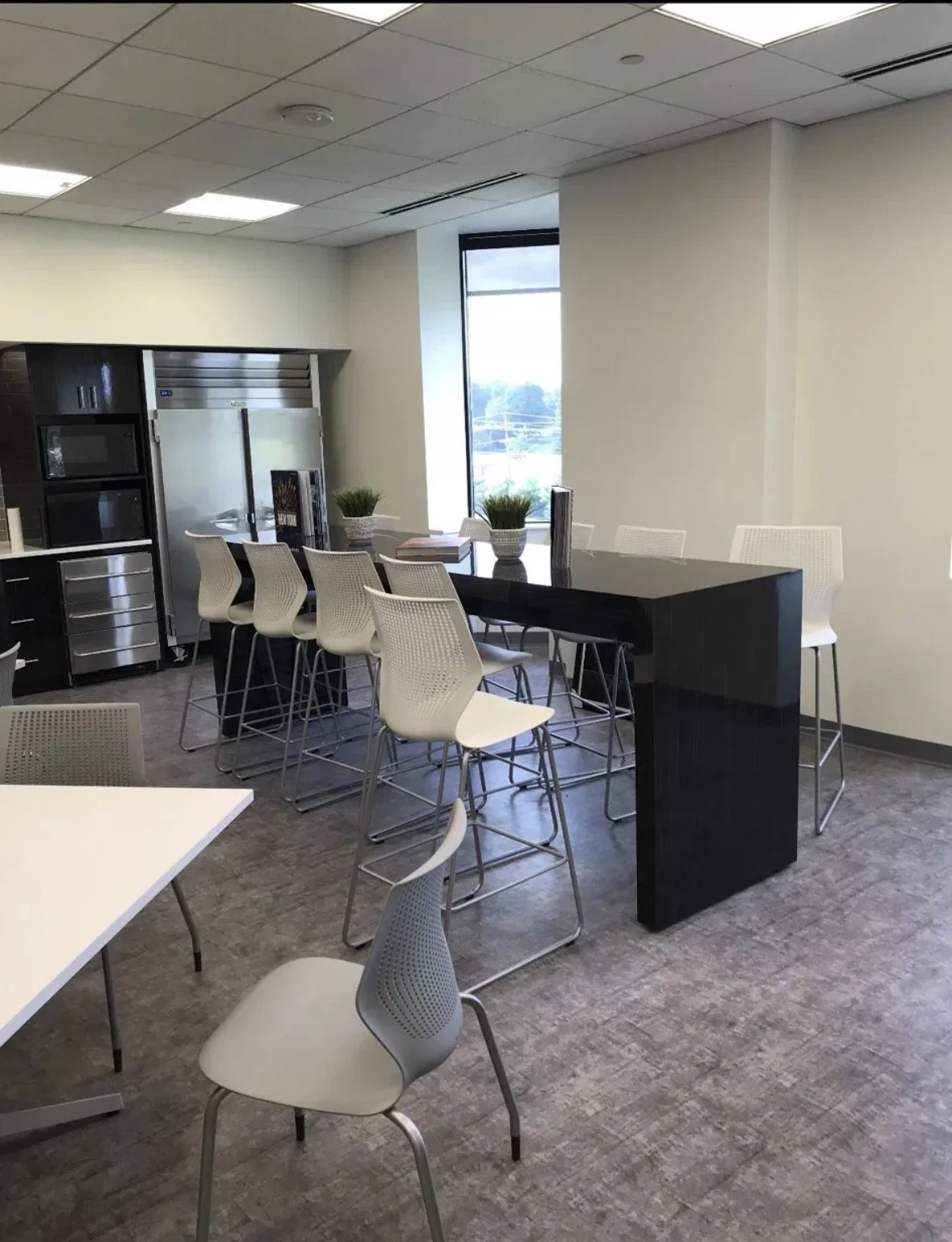 Corporate break room build-out with stone island and custom millwork by SJS Construction Group