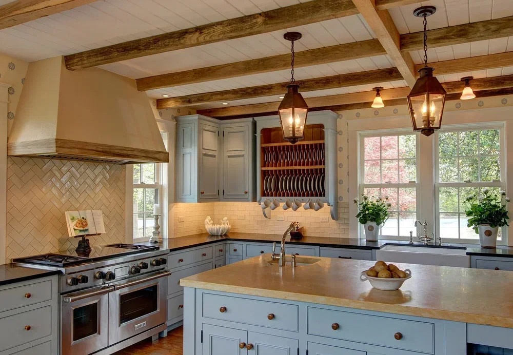 Cogswell Stone kitchen with blue cabinetry, a stone island, and exposed beams