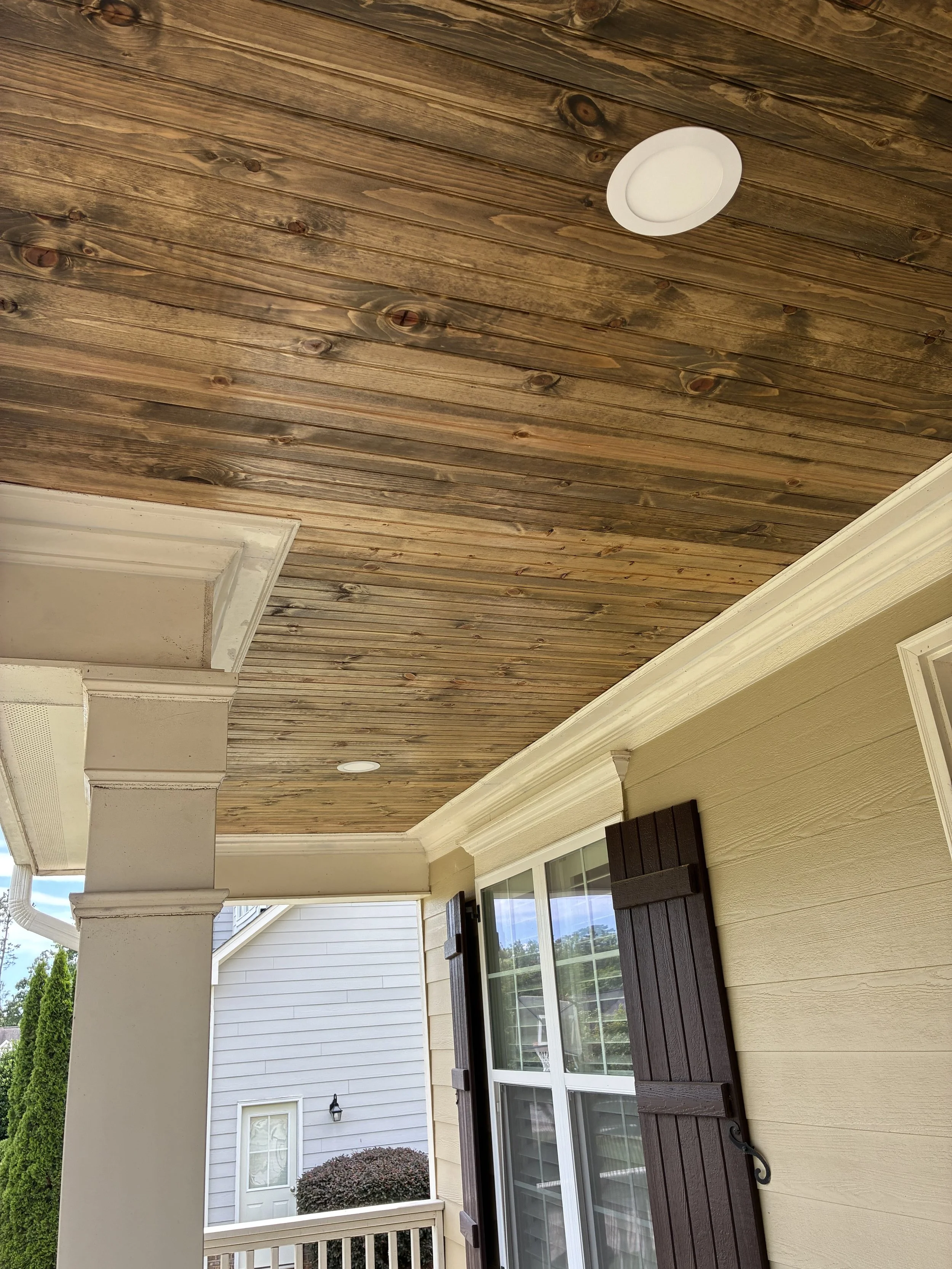 A wood ceiling adds the warmth that makes a covered porch feel like another room of the home.