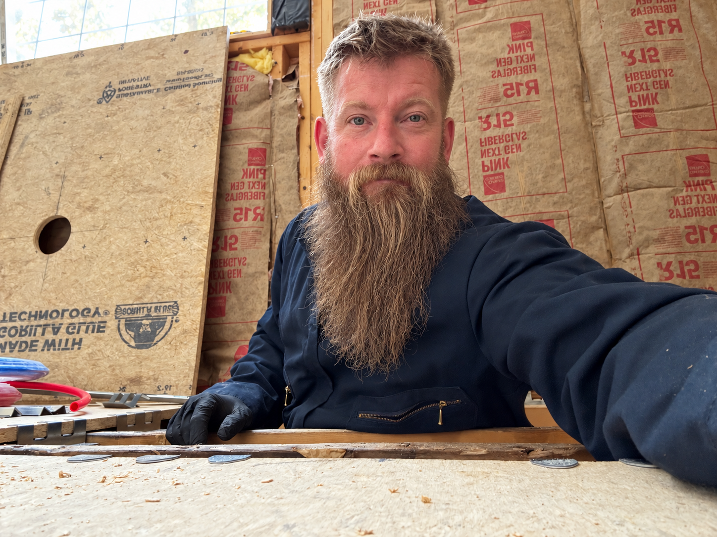 Justin Davis of Pinnacle Home Services in blue coveralls at a remodeling jobsite.