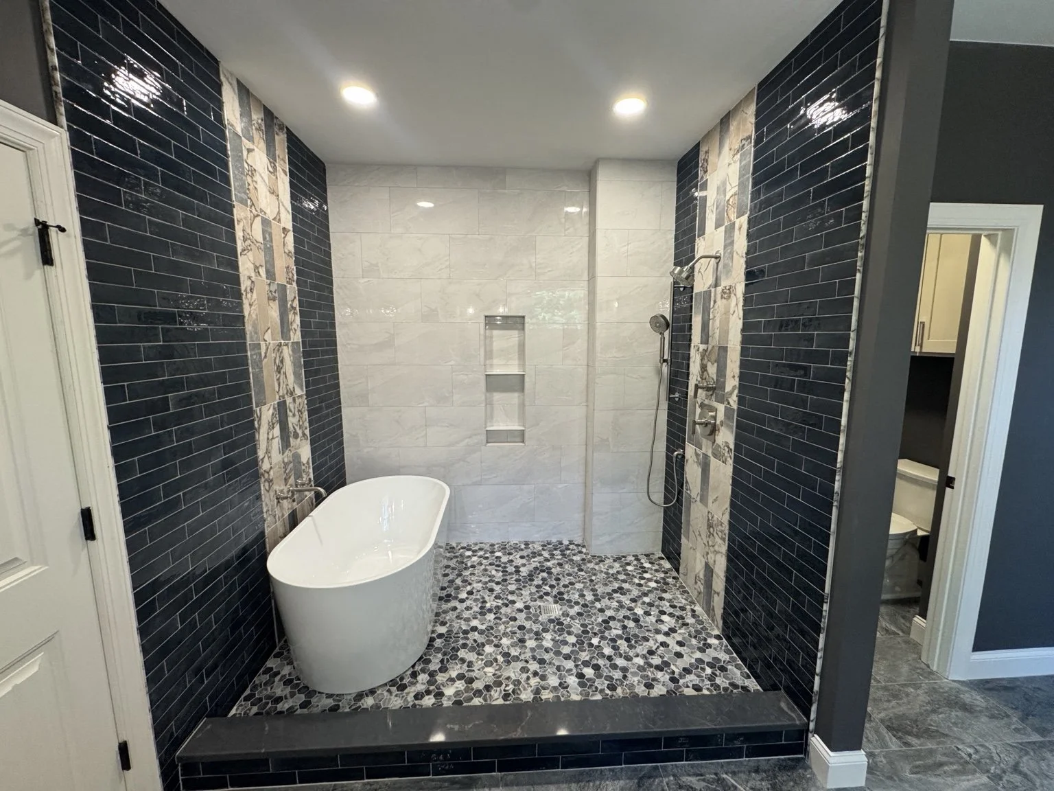 Deep blue tile wraps this tub and shower in rich color, creating a quiet place to soak and unwind at the end of the day.