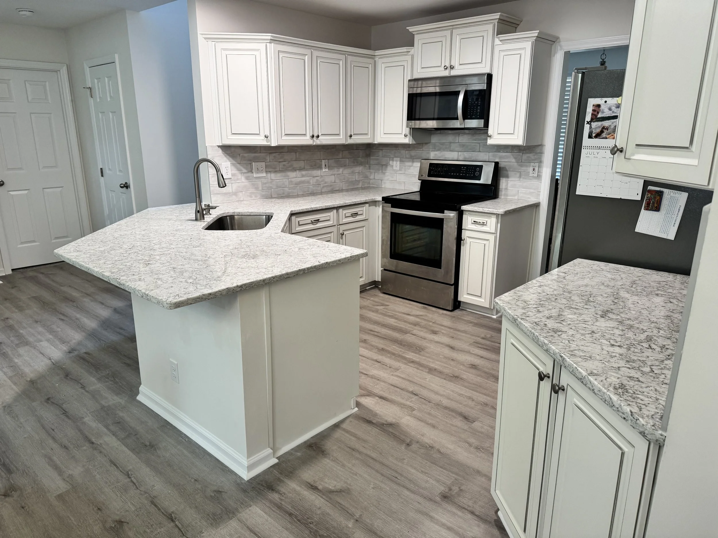 Fresh countertops and backsplash tile bring the room together, giving an everyday kitchen a welcoming new look.