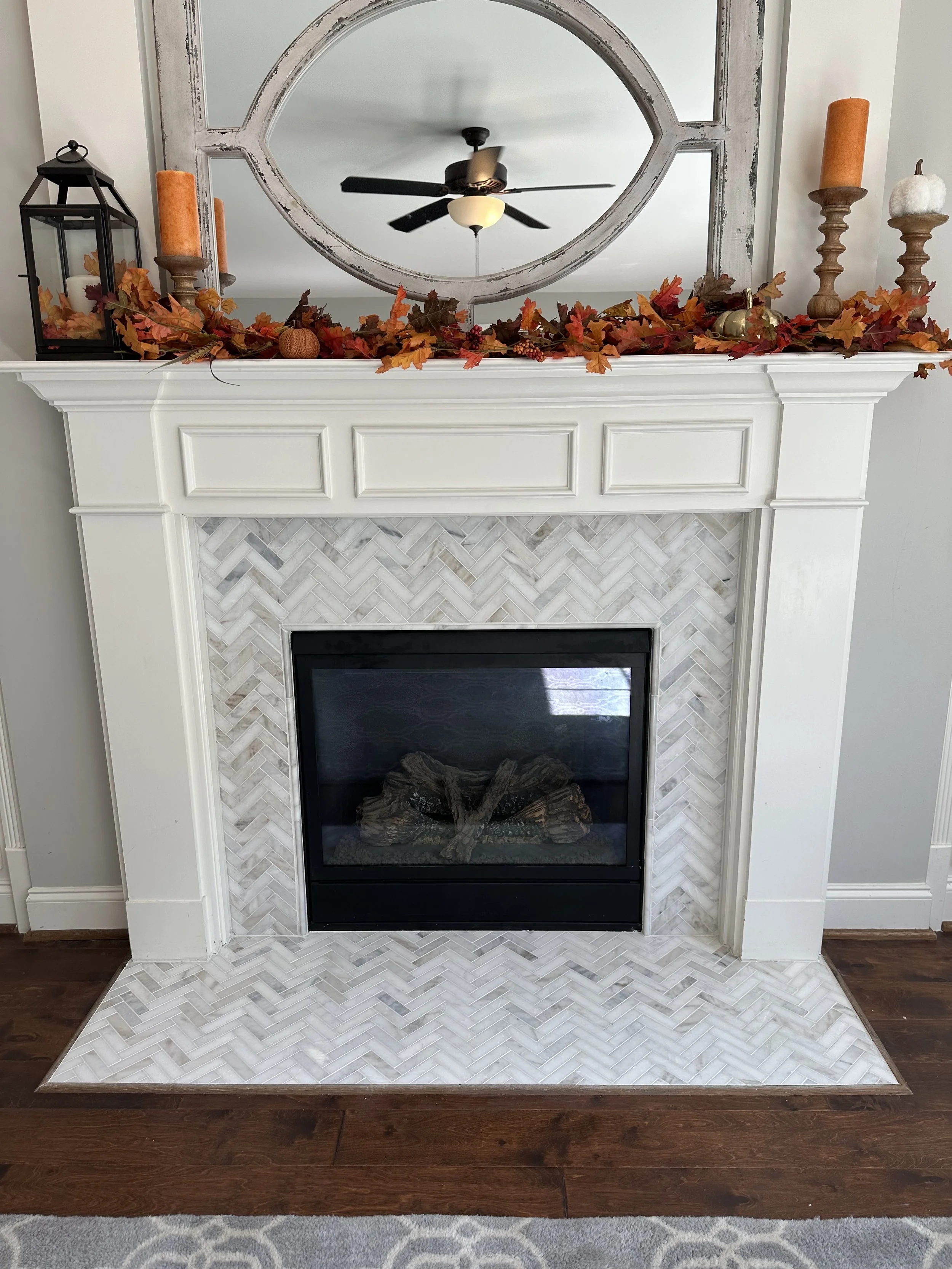 Herringbone tile and a detailed white mantel give this fireplace a fresh look and a welcoming place to gather.