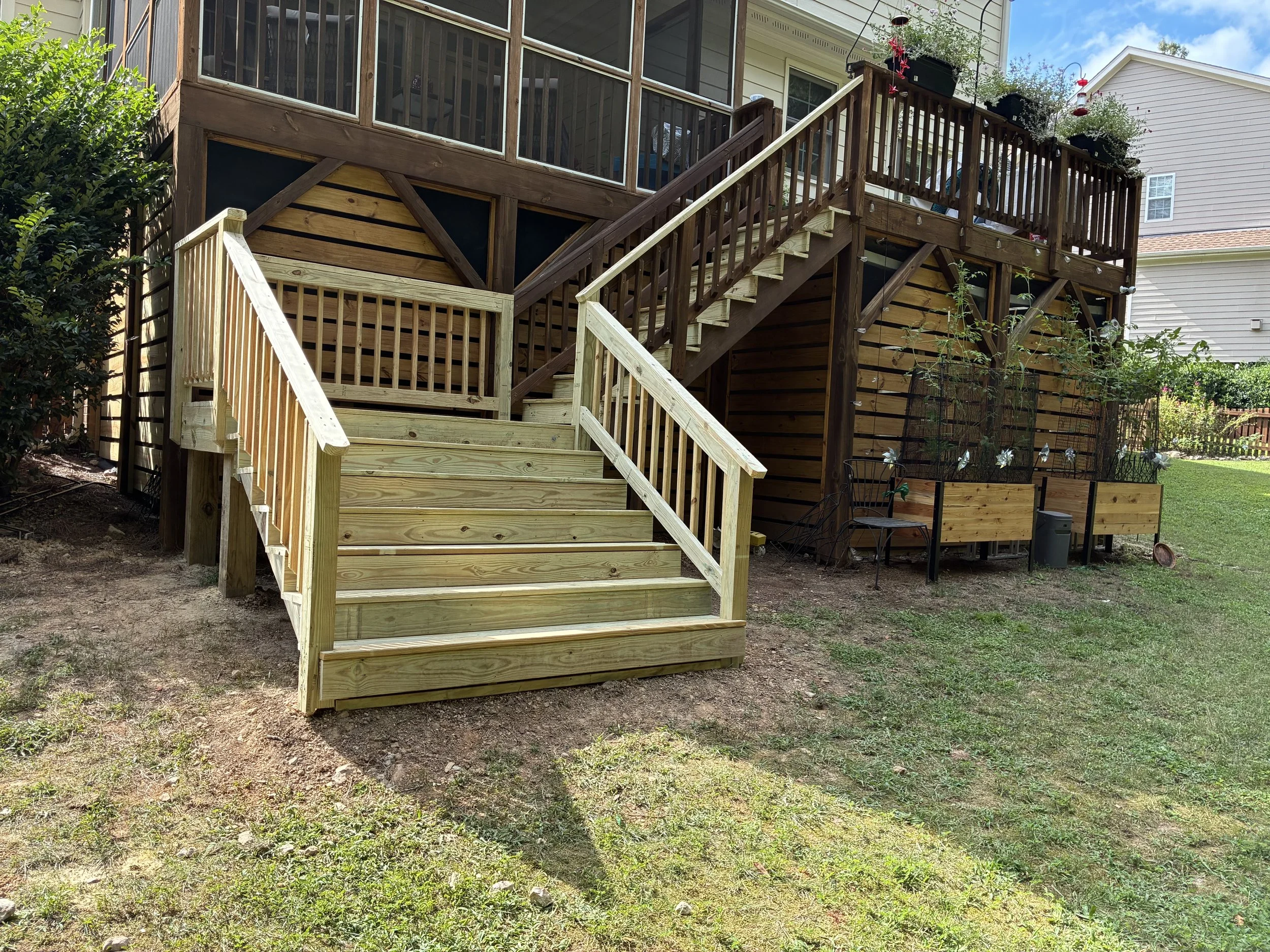 A wood stairway connects the deck to the yard, making it easier to move between outdoor spaces.