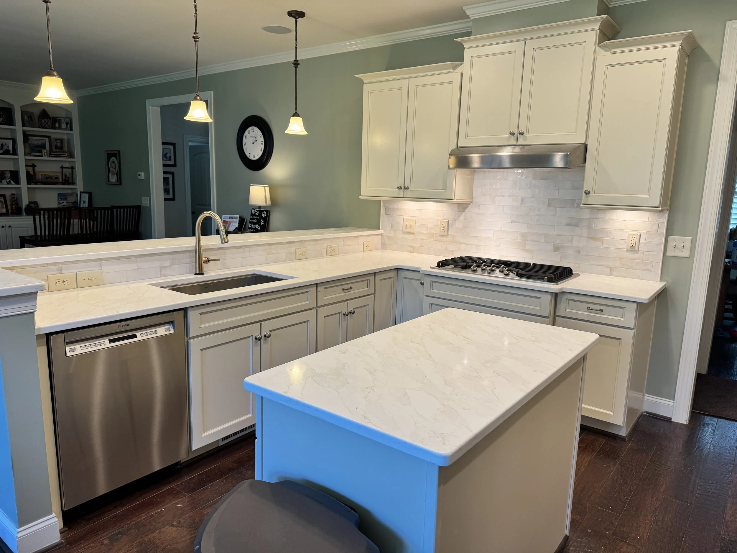 New countertops, a sink, and a tile backsplash brighten this kitchen while the existing cabinets keep its familiar charm. A few thoughtful changes make the whole room feel refreshed.