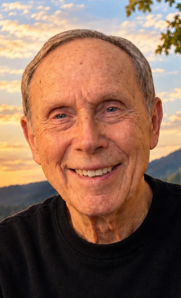 Close-up portrait of Pop smiling against a peaceful sunset landscape.